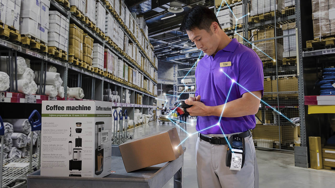 A retail associate looks at items on a cart in a back-of-store warehouse