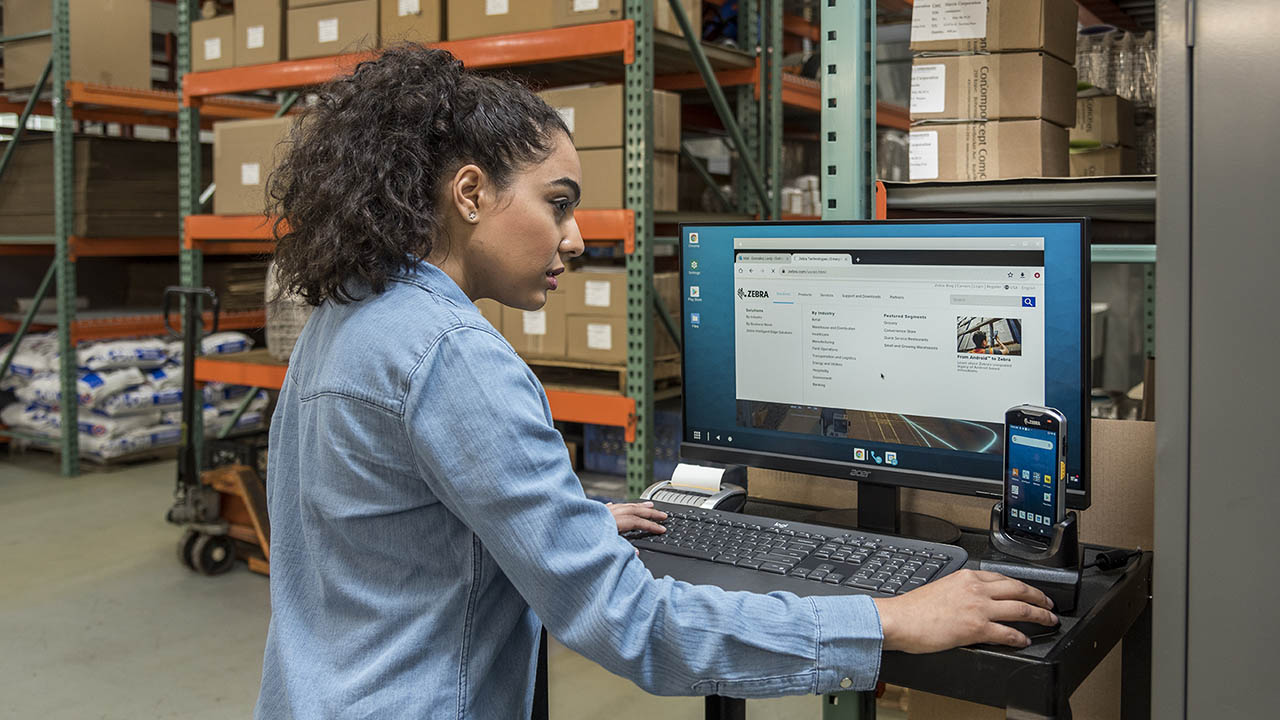 A female warehouse worker uses a mobile workstation