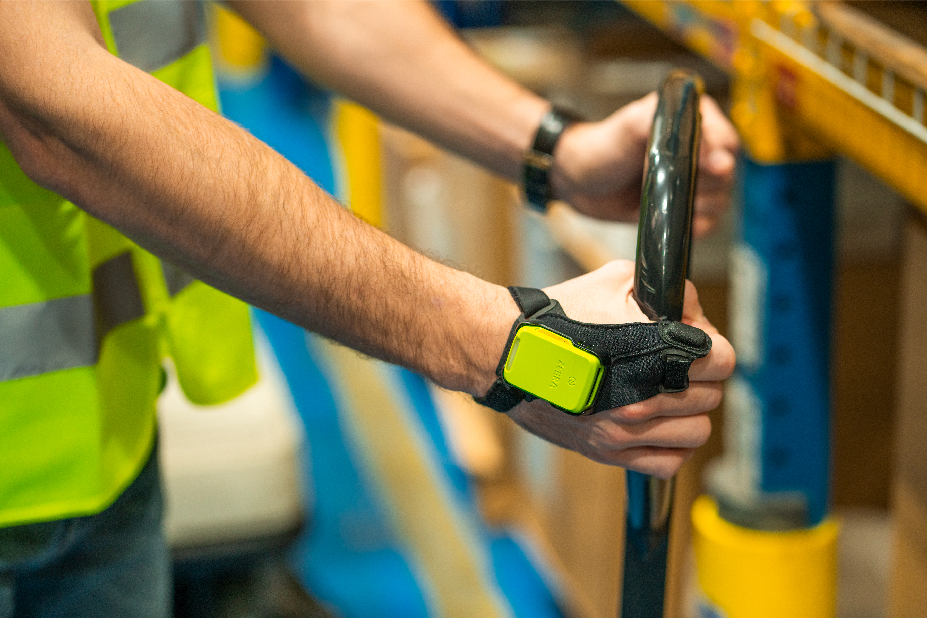 A worker with a wearable computer on their hand moves items in a warehouse