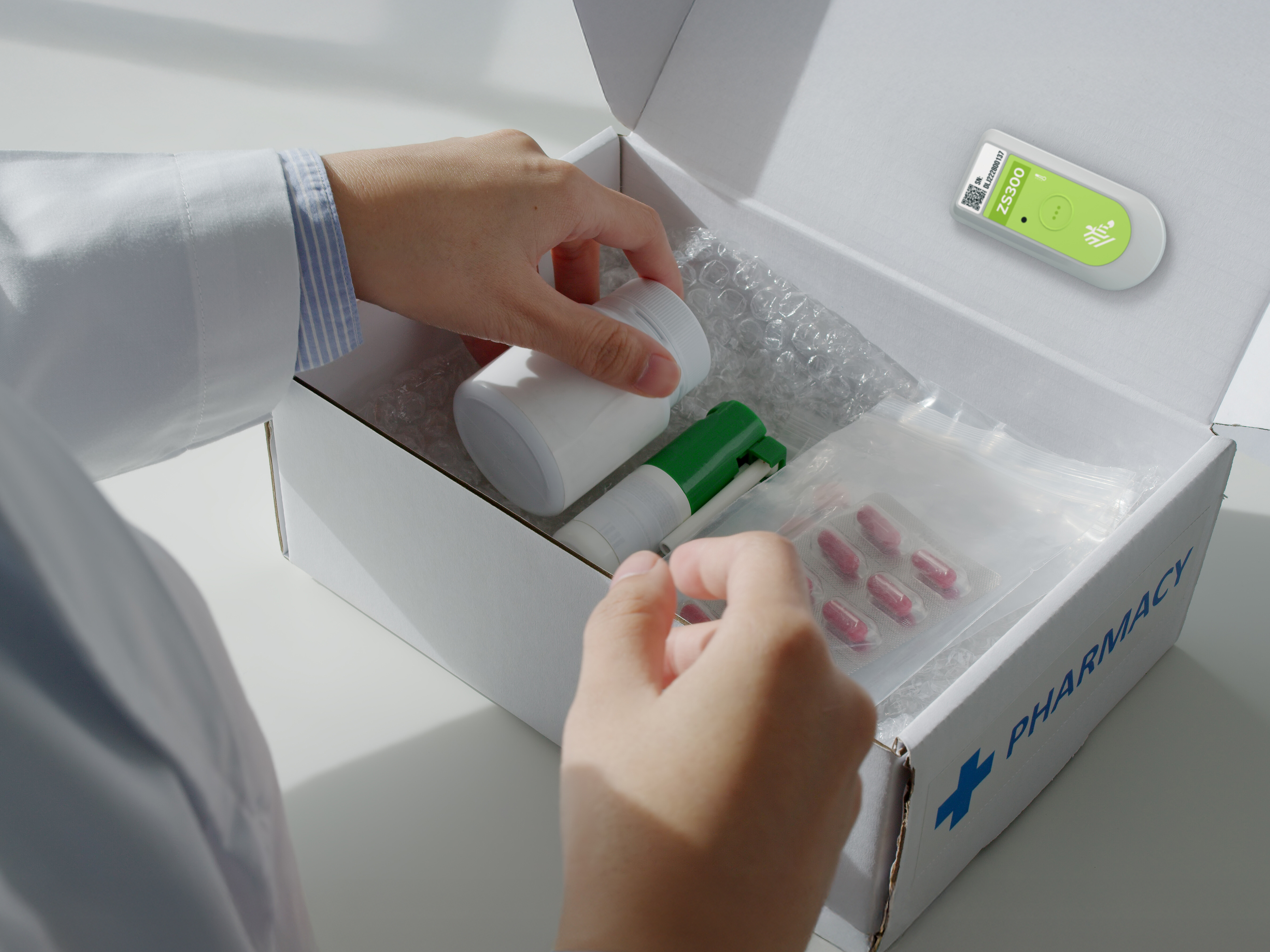Pharmacy products being packed in a box with a Zebra ZS300