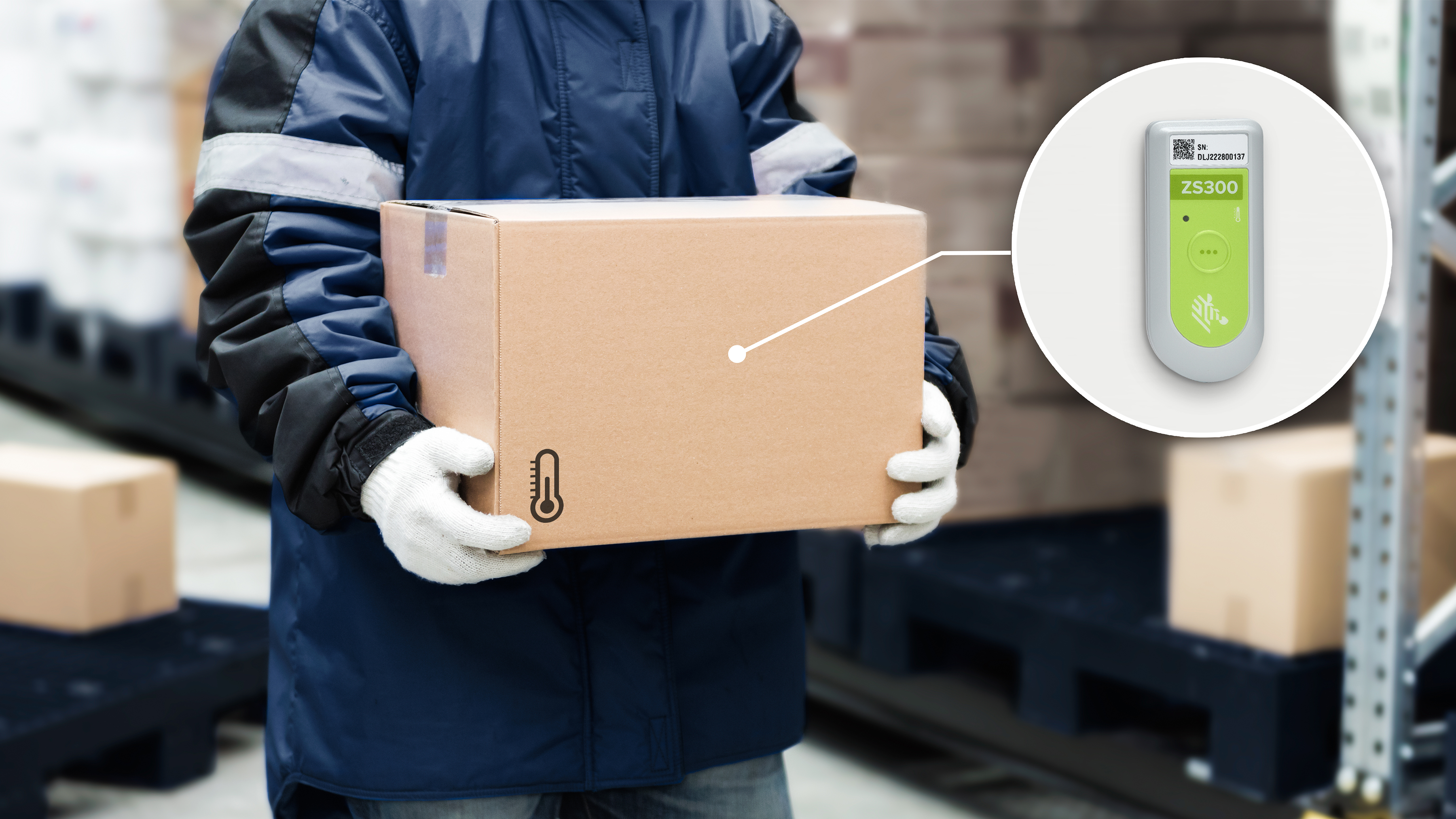 A temperature monitored package being held by a warehouse worker