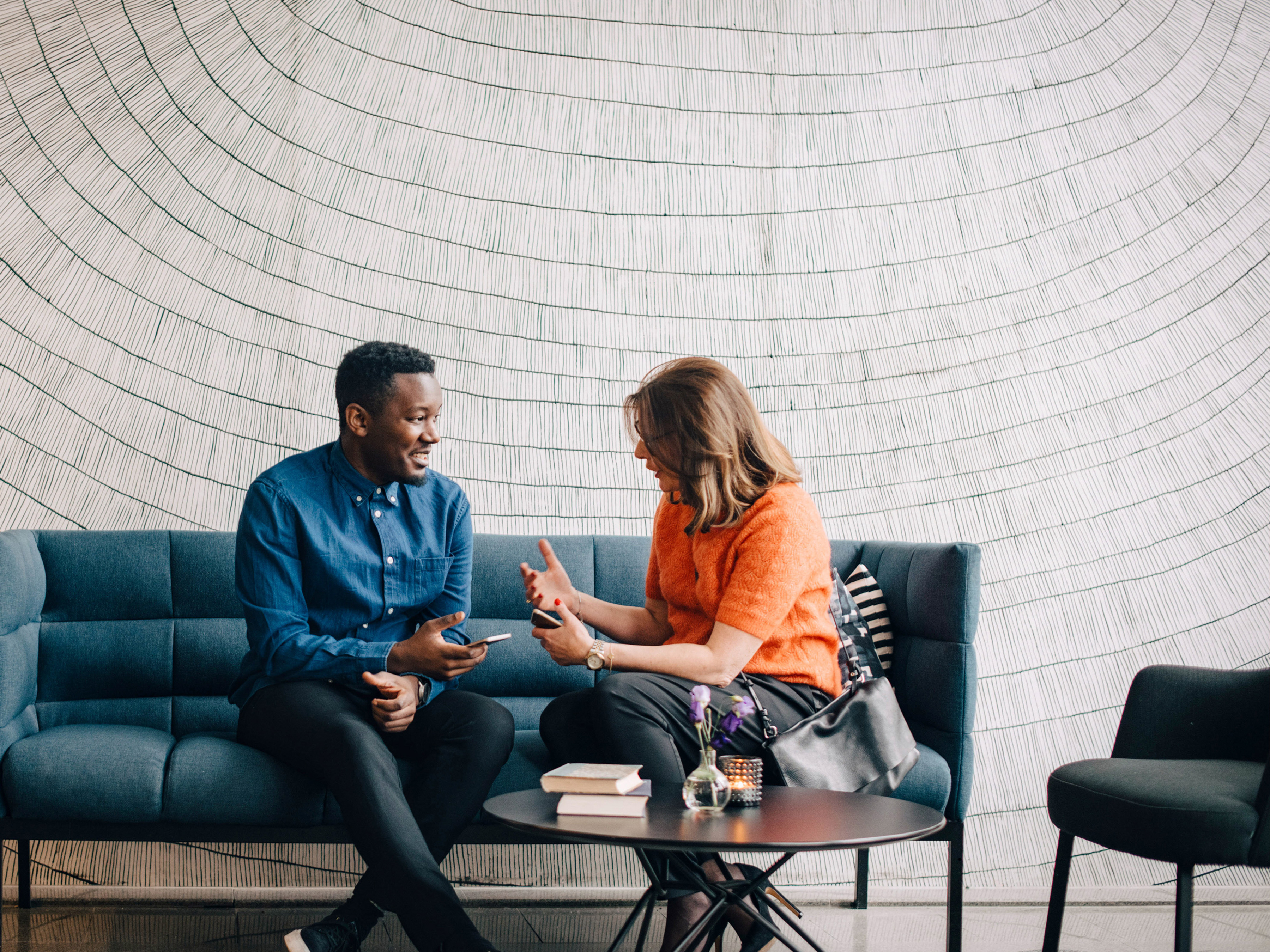 Two coworkers speaking in a modern office.