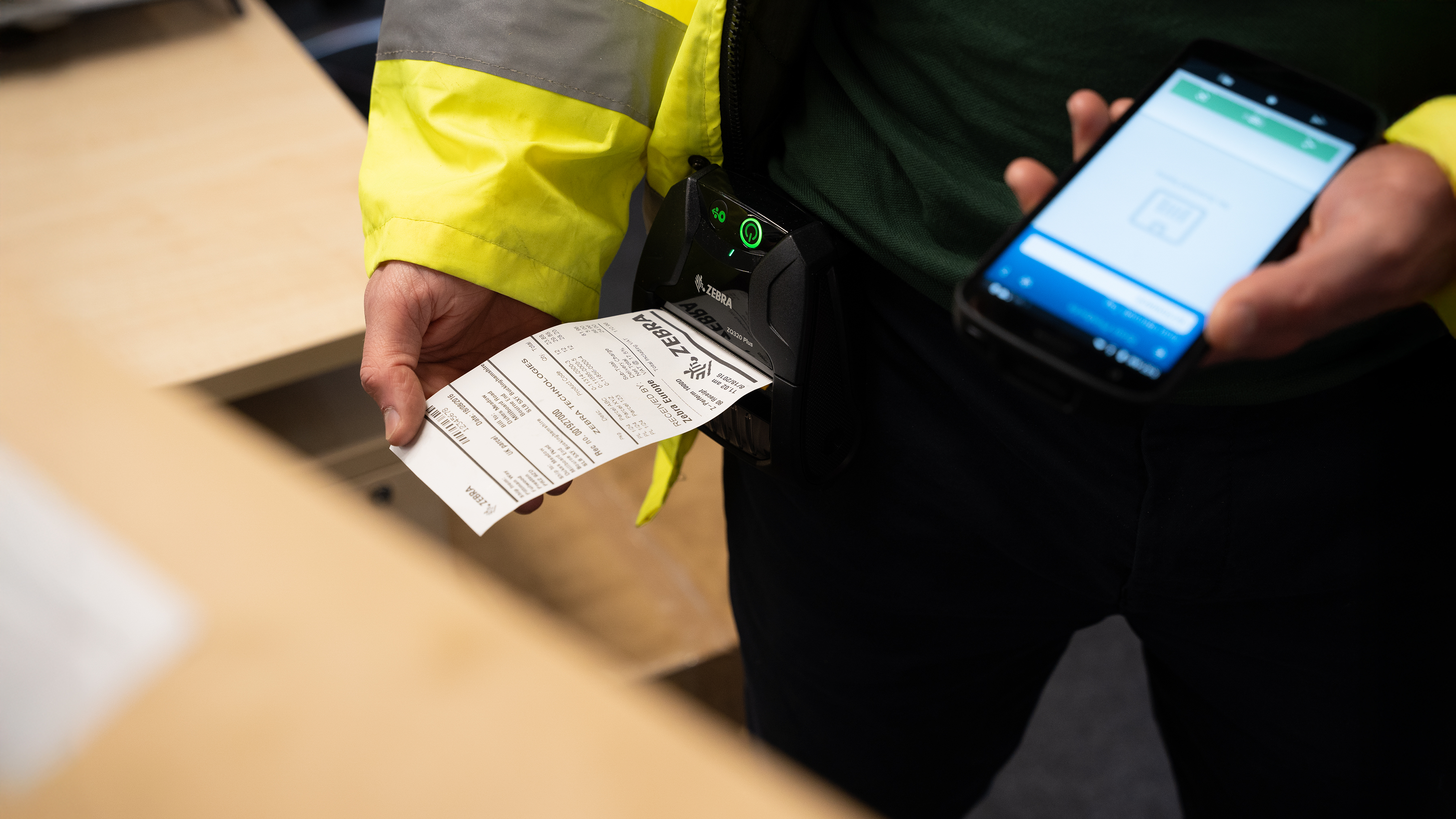 Field operations worker printers a label on a Zebra mobile printer.