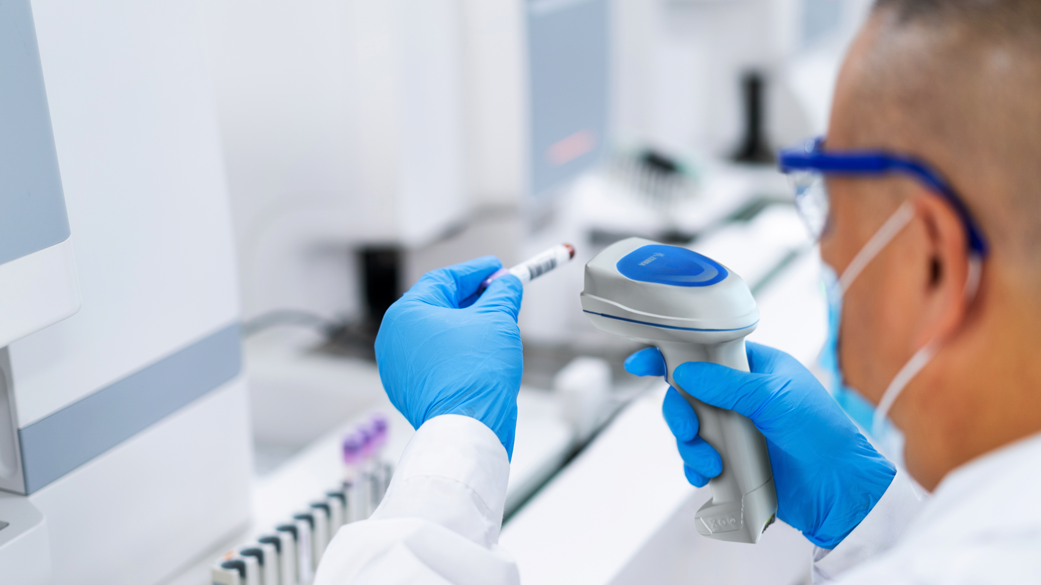 Lab worker using a Zebra handheld scanner to process a specimen.