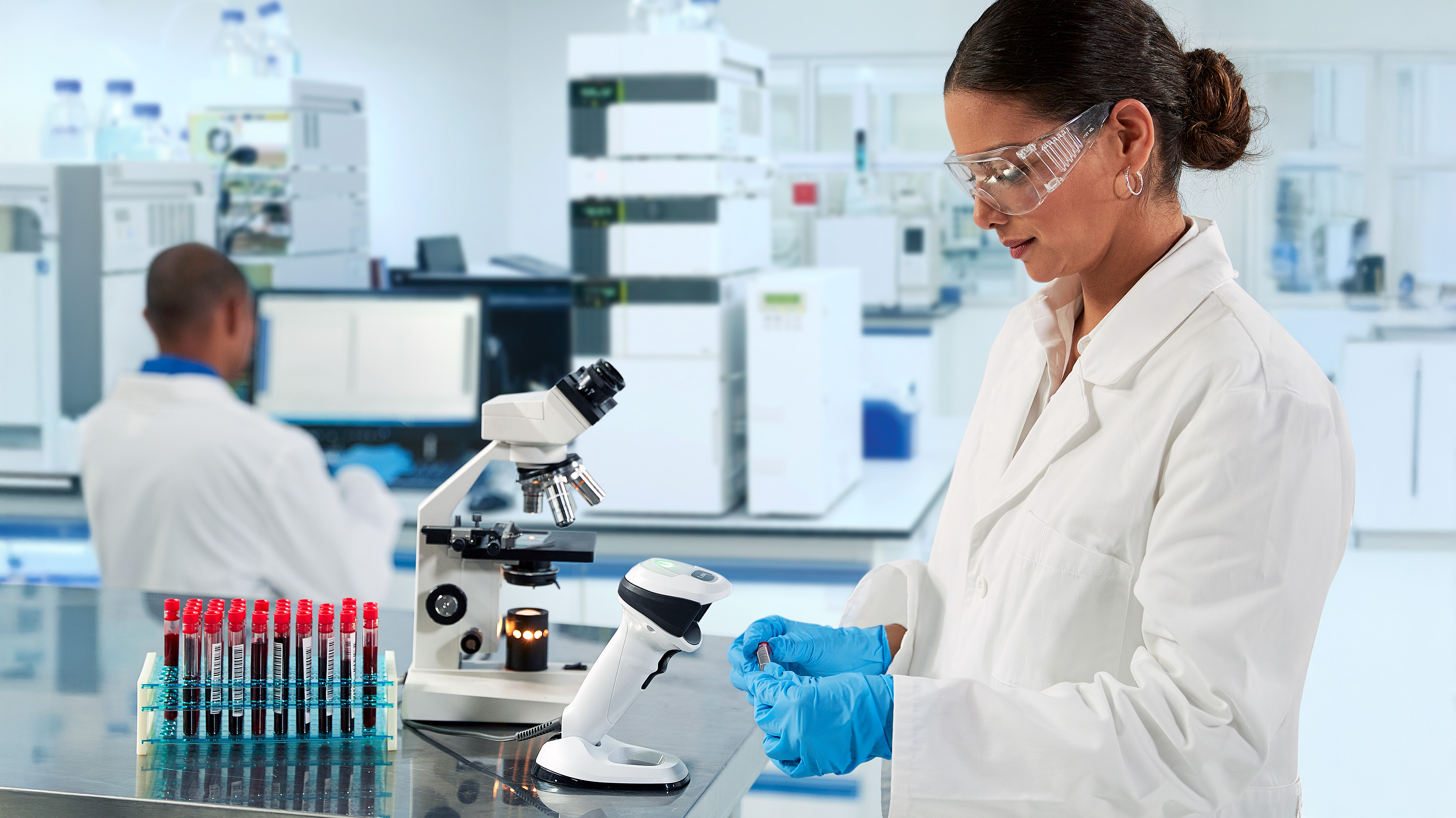 Laboratory worker in goggles doing a research using a microscope
