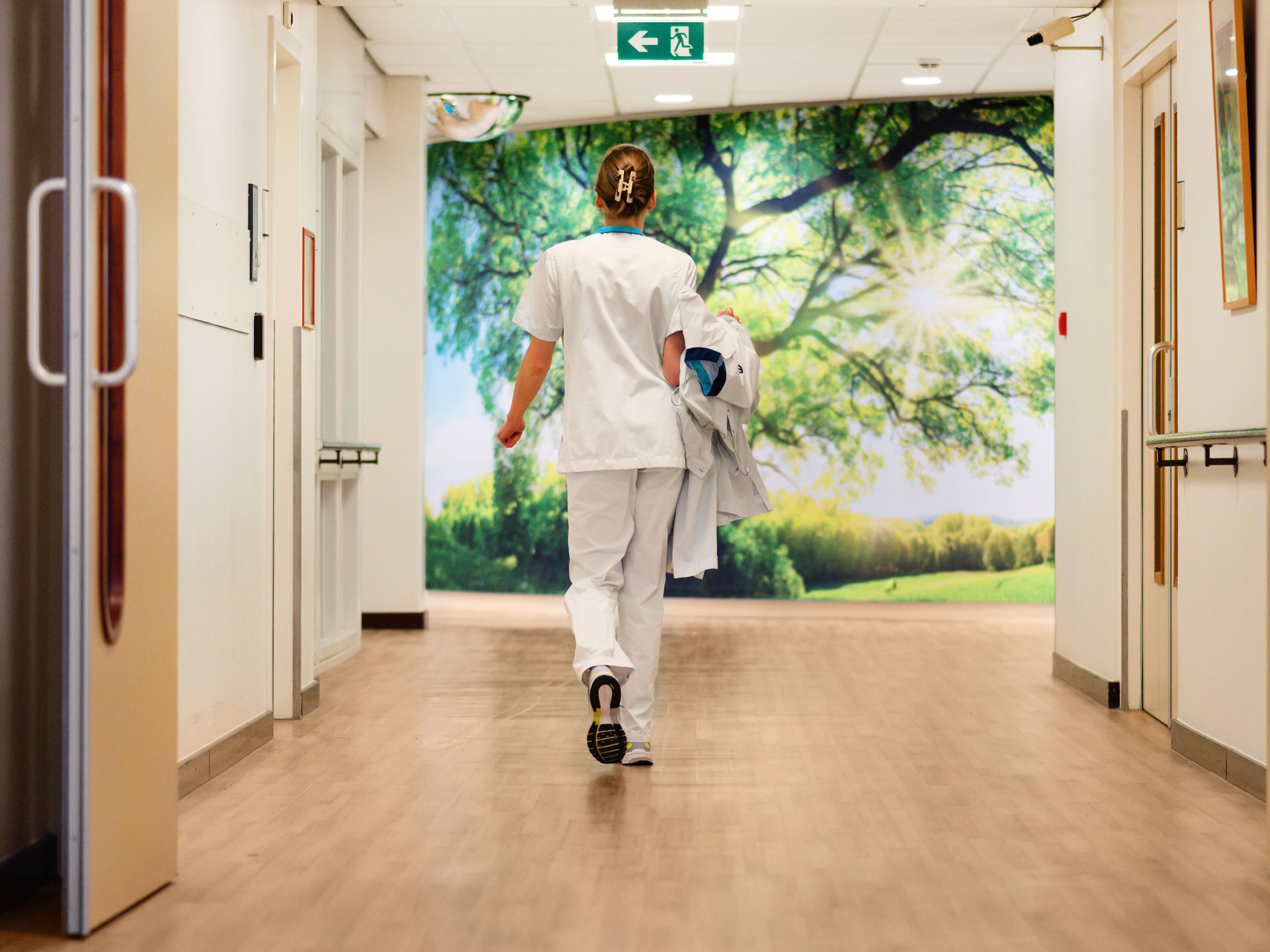 healthcare-photography-website-nurse-back-hospital-corridor-far-4x3-3600x2700