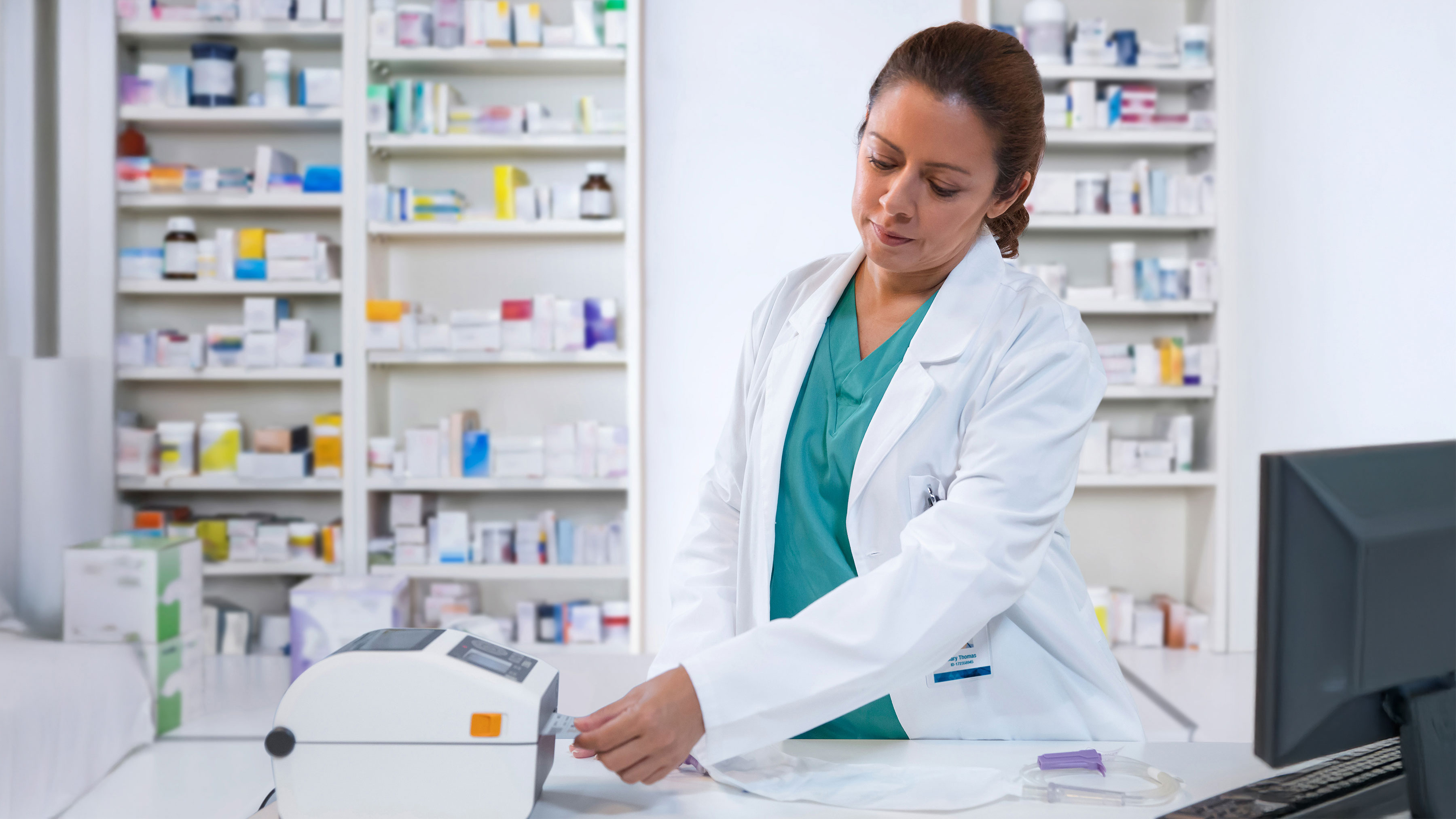 Pharmacist using a Zebra desktop healthcare printer to create a label.