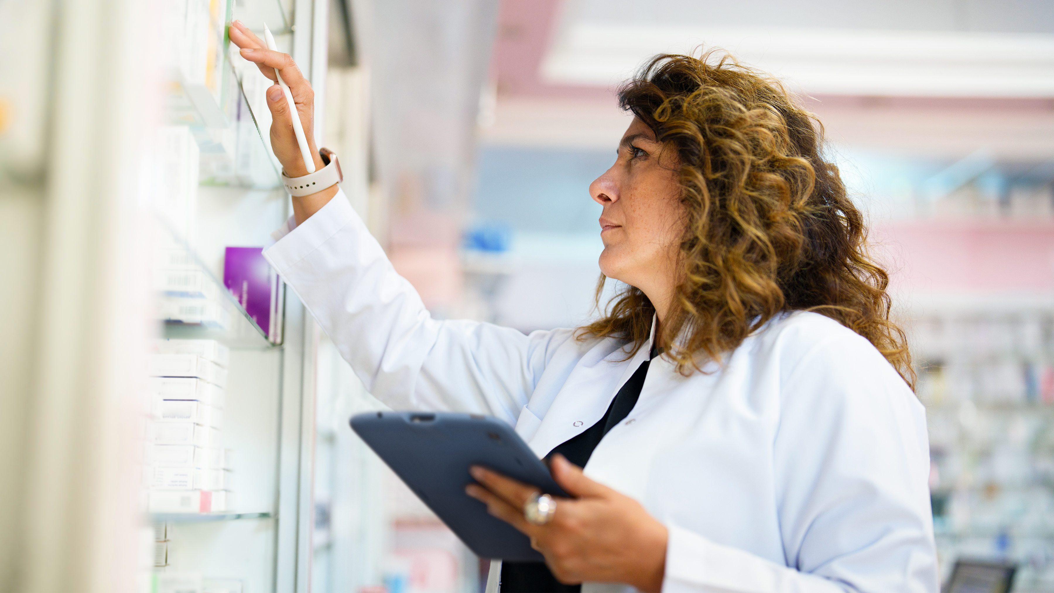 Pharmacist managing inventory with a Zebra tablet.