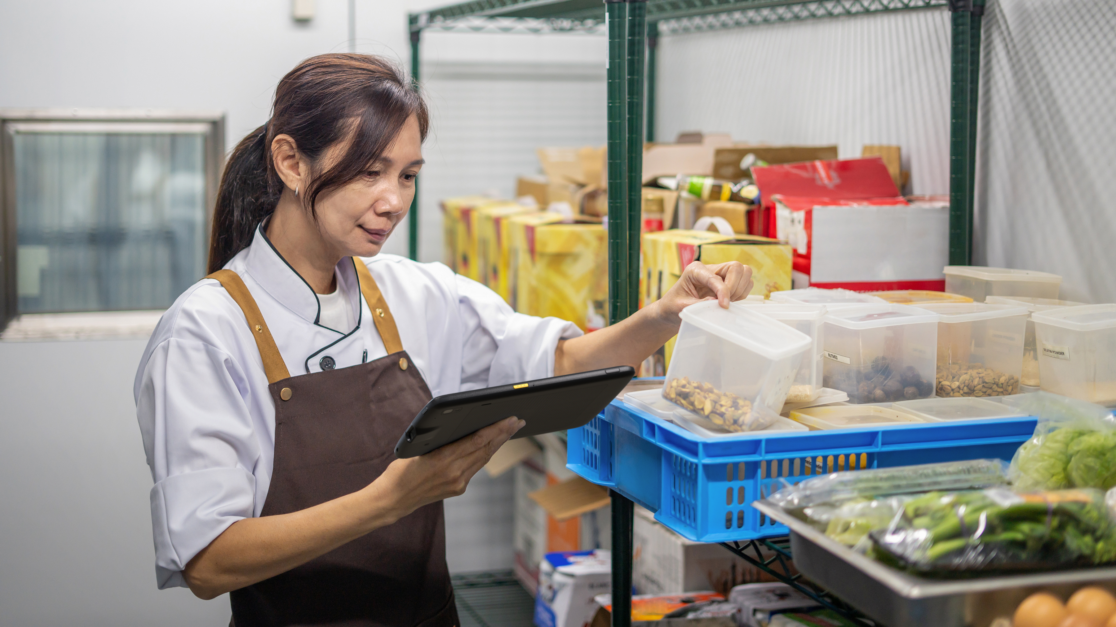 Hospitality worker checking food inventory with a Zebra tablet