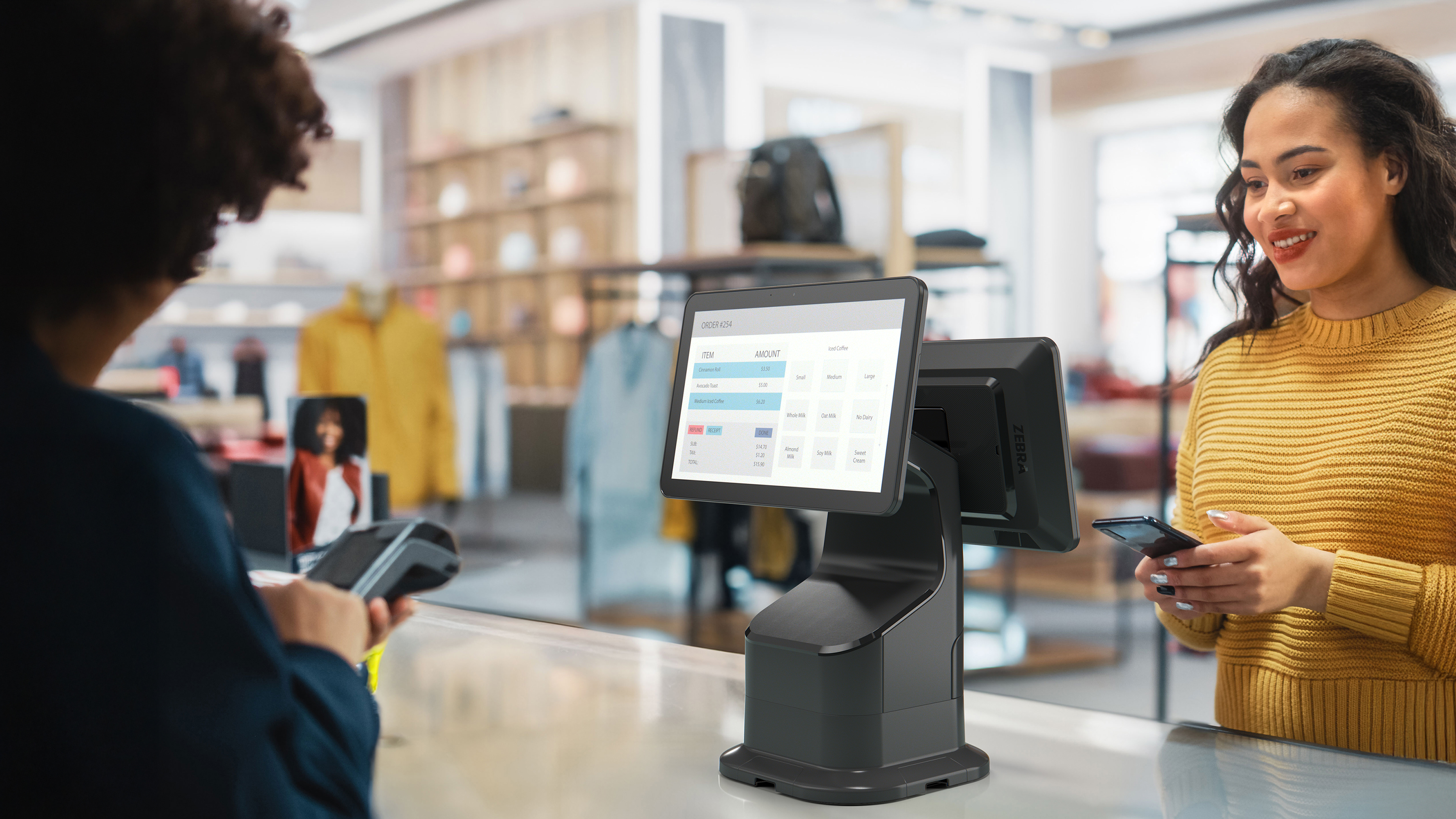Retail cashier processing a purchase on a Zebra Interactive Kiosk. 
