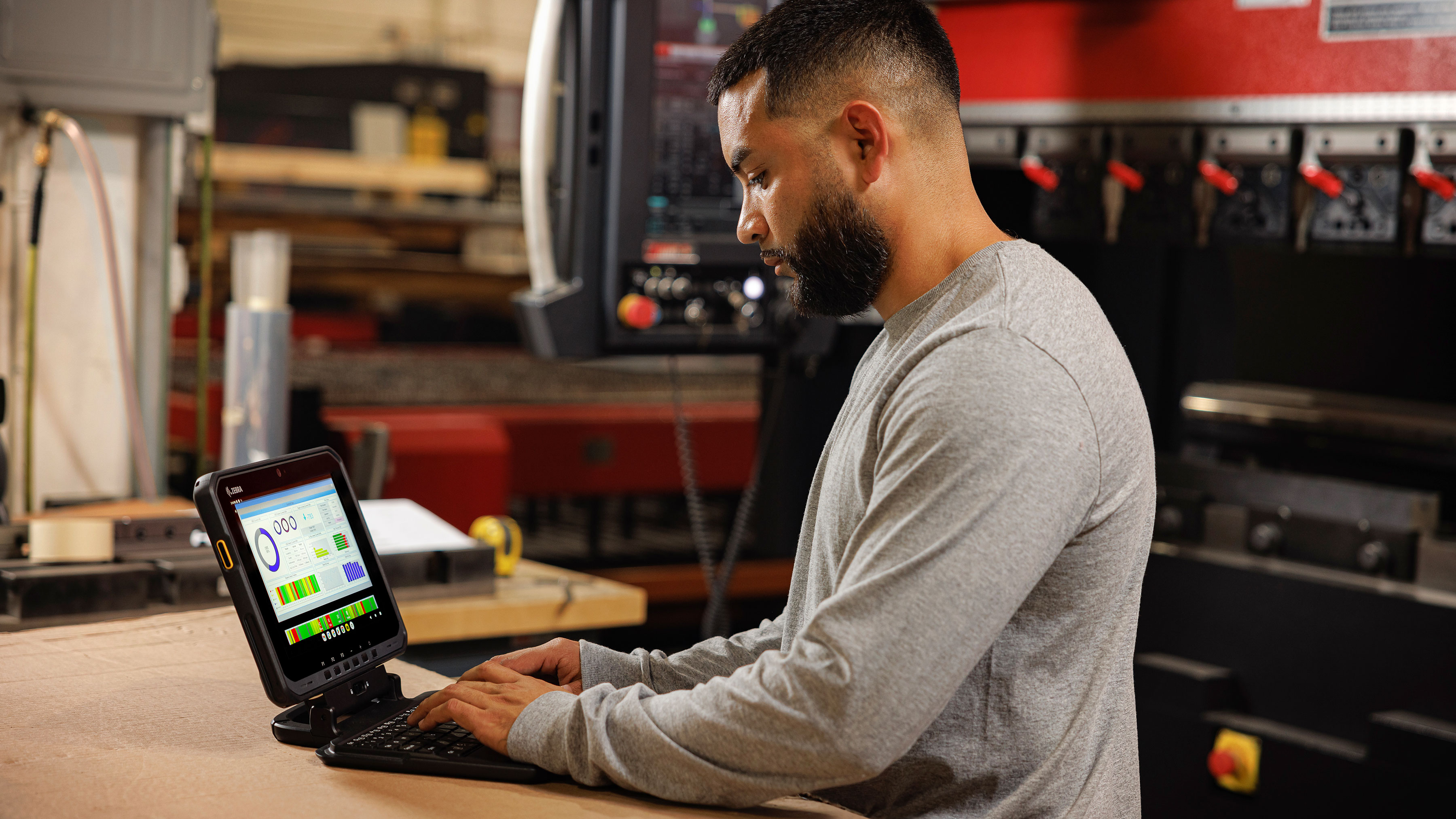 Employee using a Zebra tablet in a manufacturing setting.