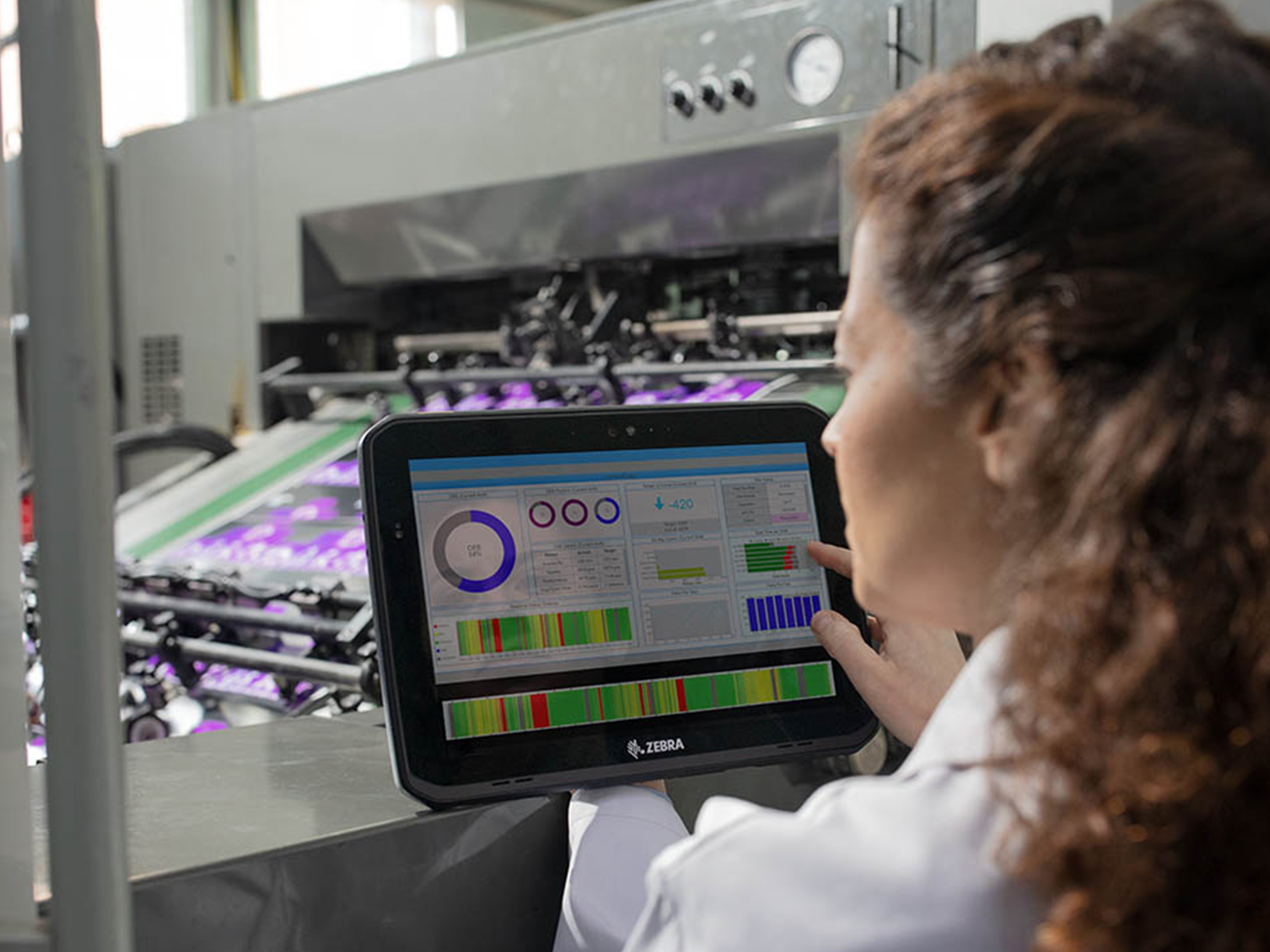 Manufacturing worker monitoring a machine using a Zebra tablet.