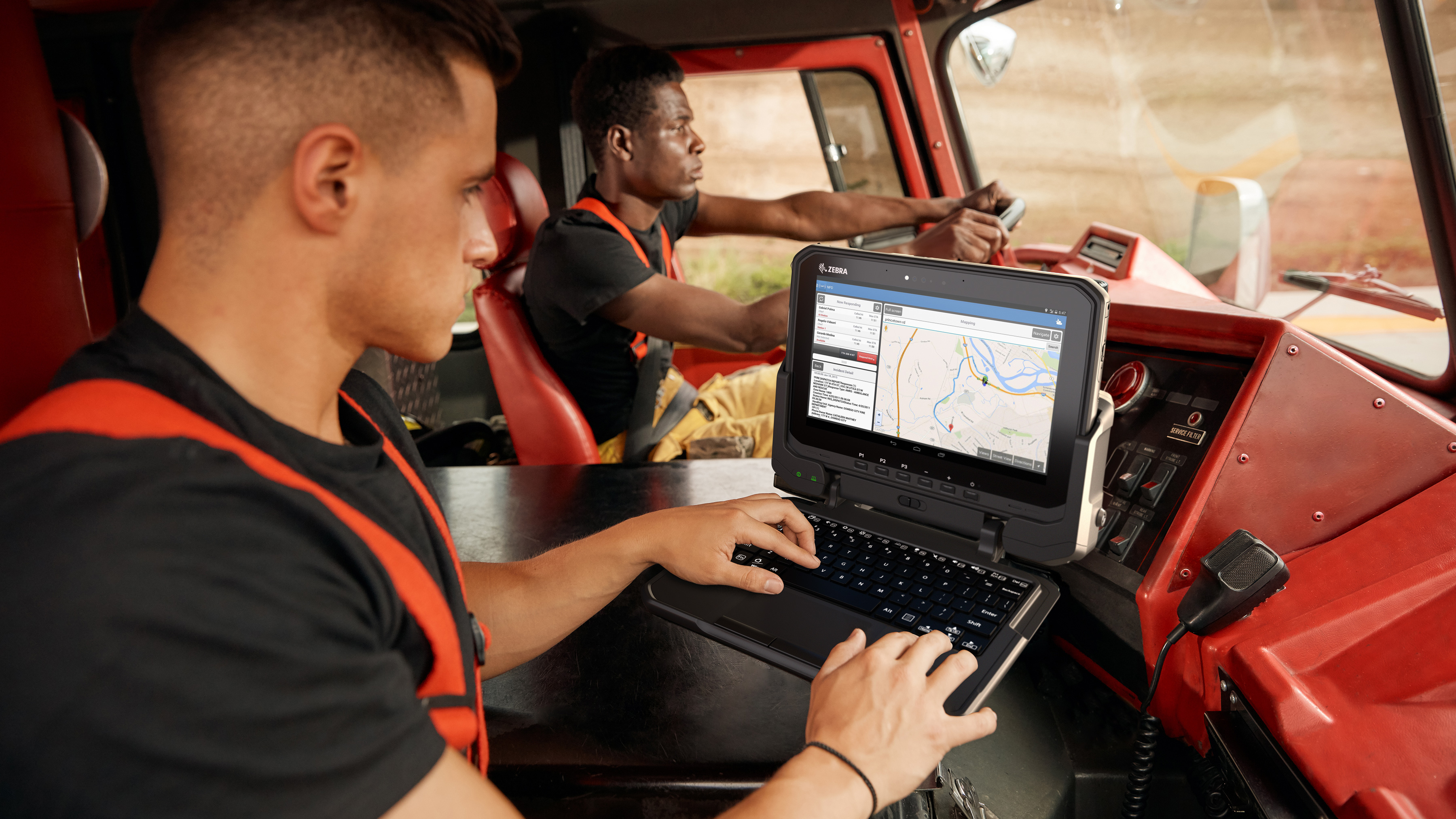 Firefighters using Zebra tablet in a fire truck.