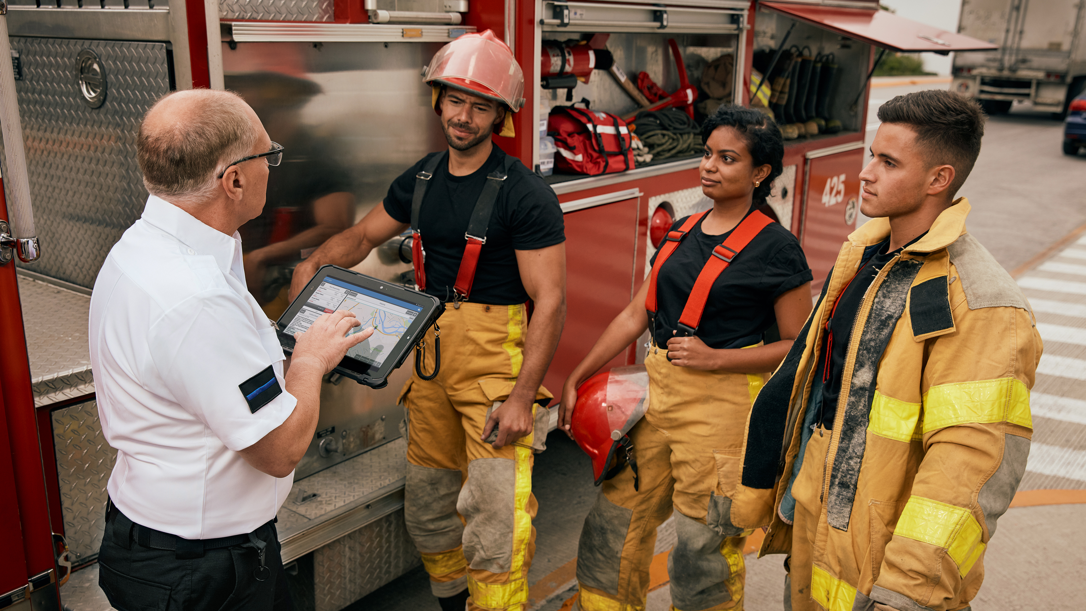Firefighters and fire chief having a meeting with a Zebra rugged tablet.