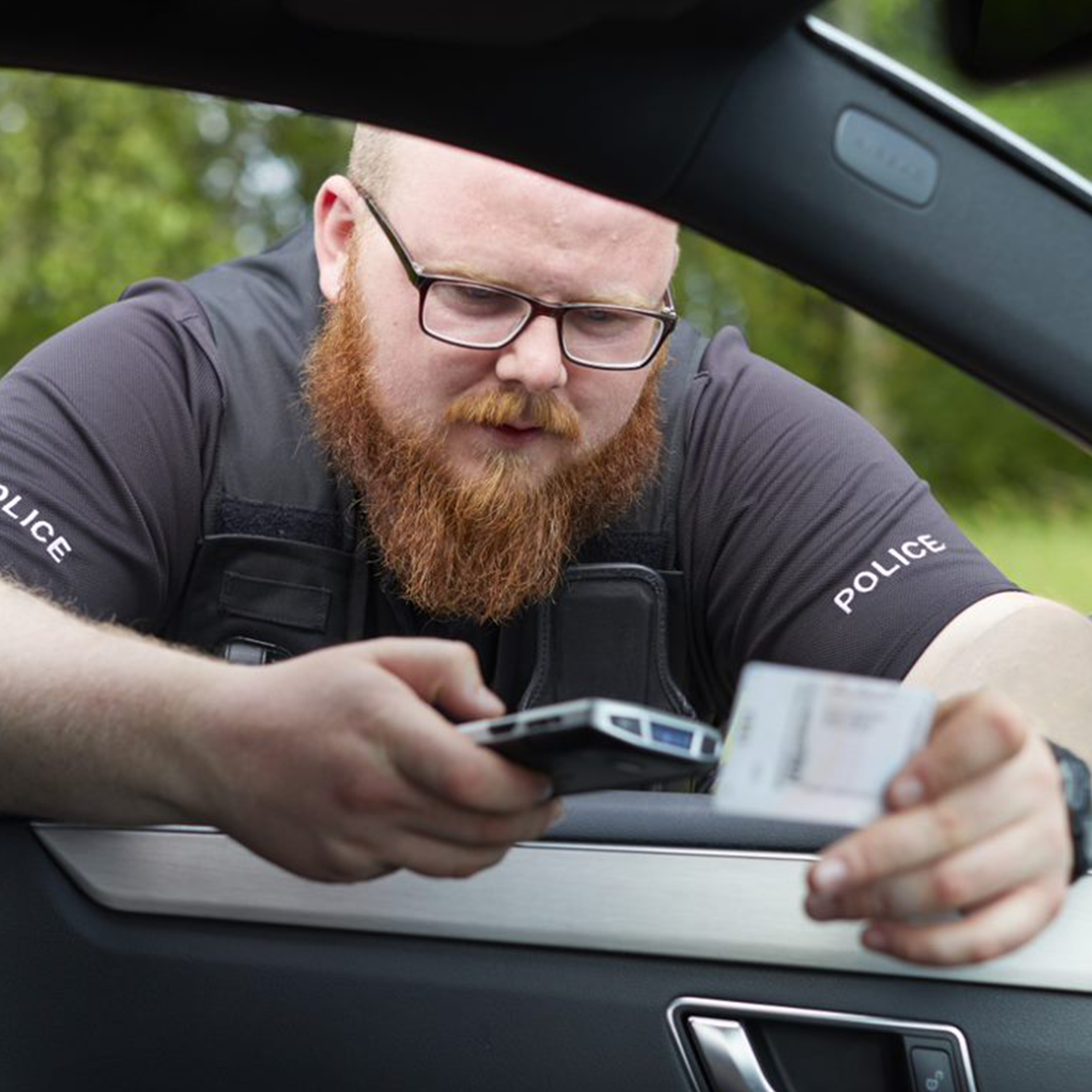 public sector photography website police officer handheld in hand checking driver licence