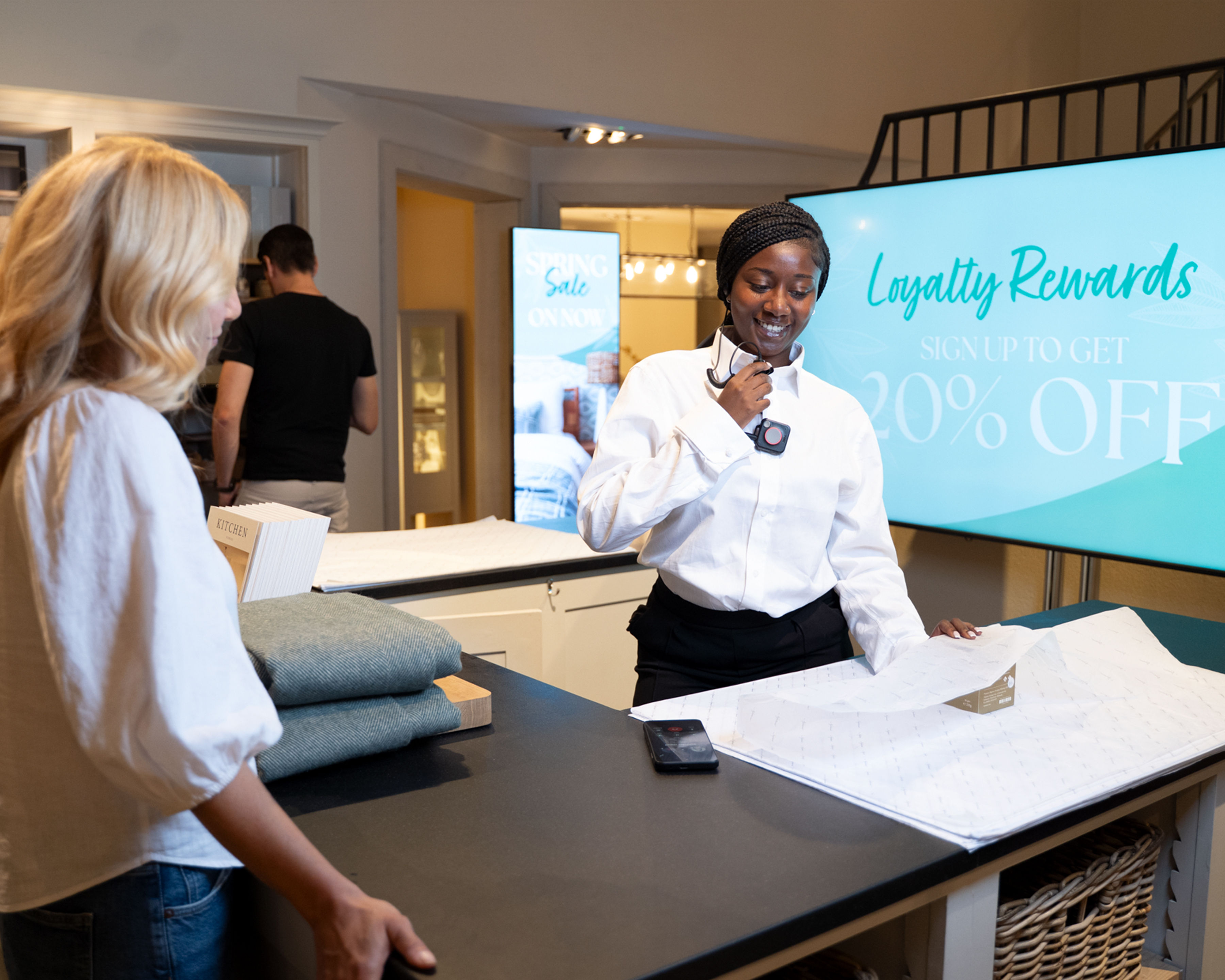 Retail worker using ZEC500, EM45 and WS101 for in-store digital display promoitions