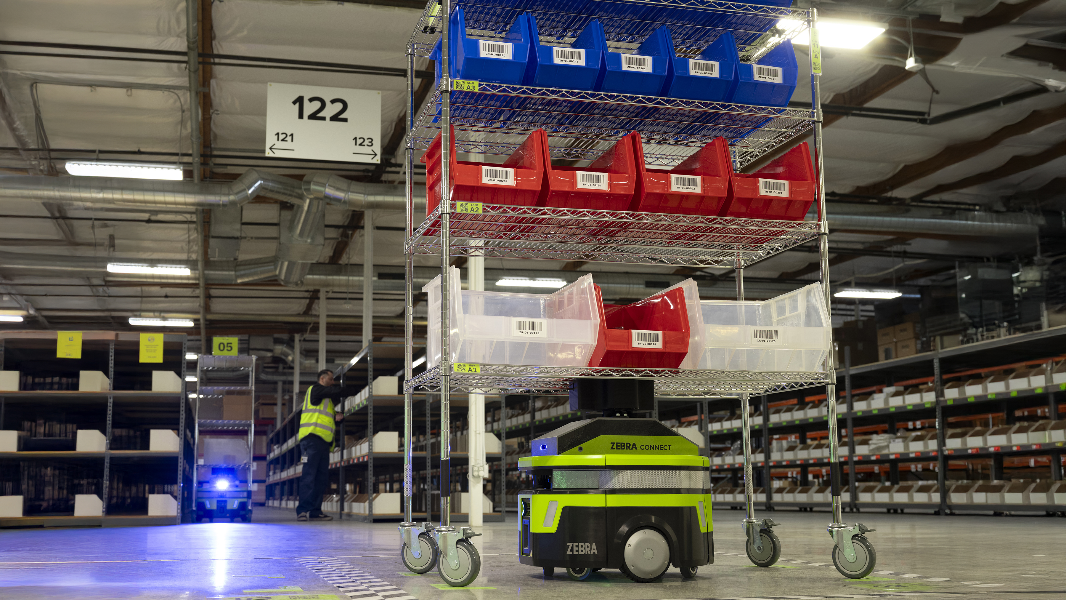 Zebra mobile robot carrying boxes in a warehouse with shelves in the background