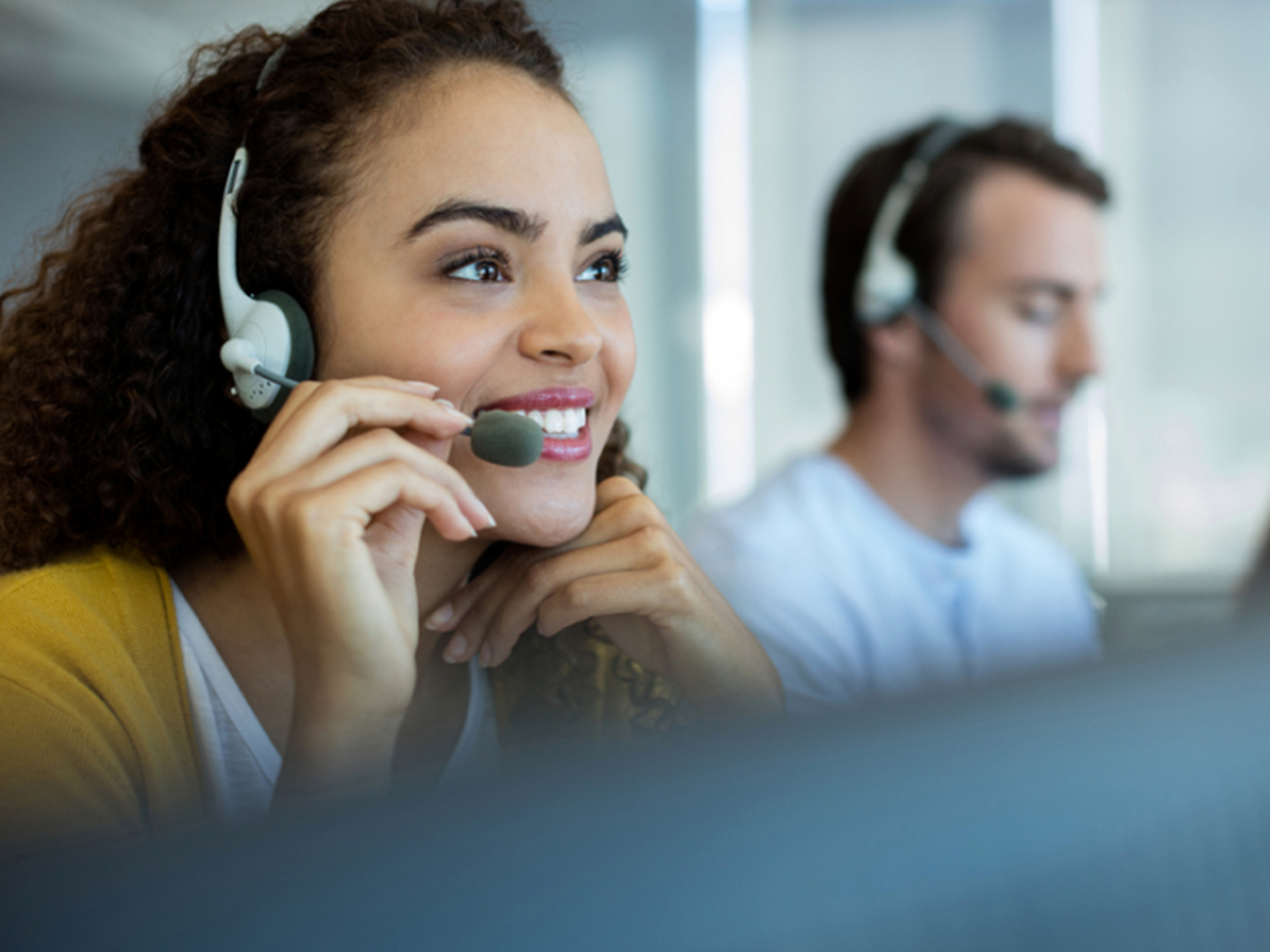 Customer service representatives using headphones in an office setting.