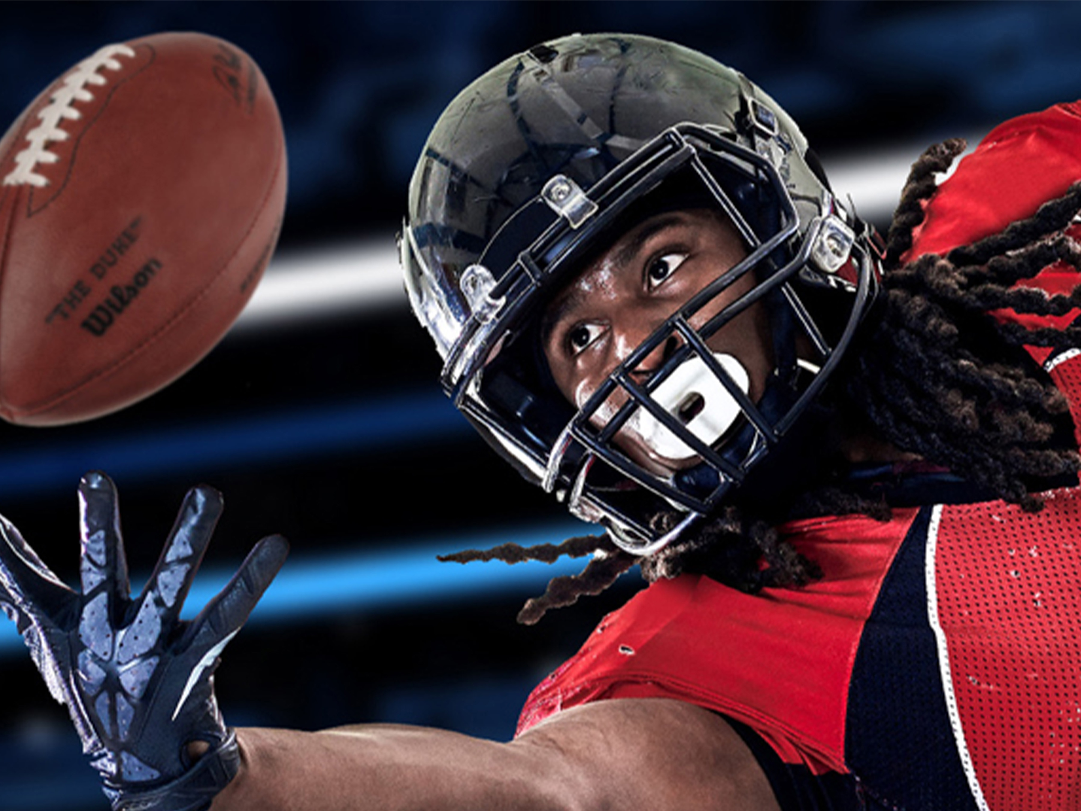 Football player reaching for the ball. 