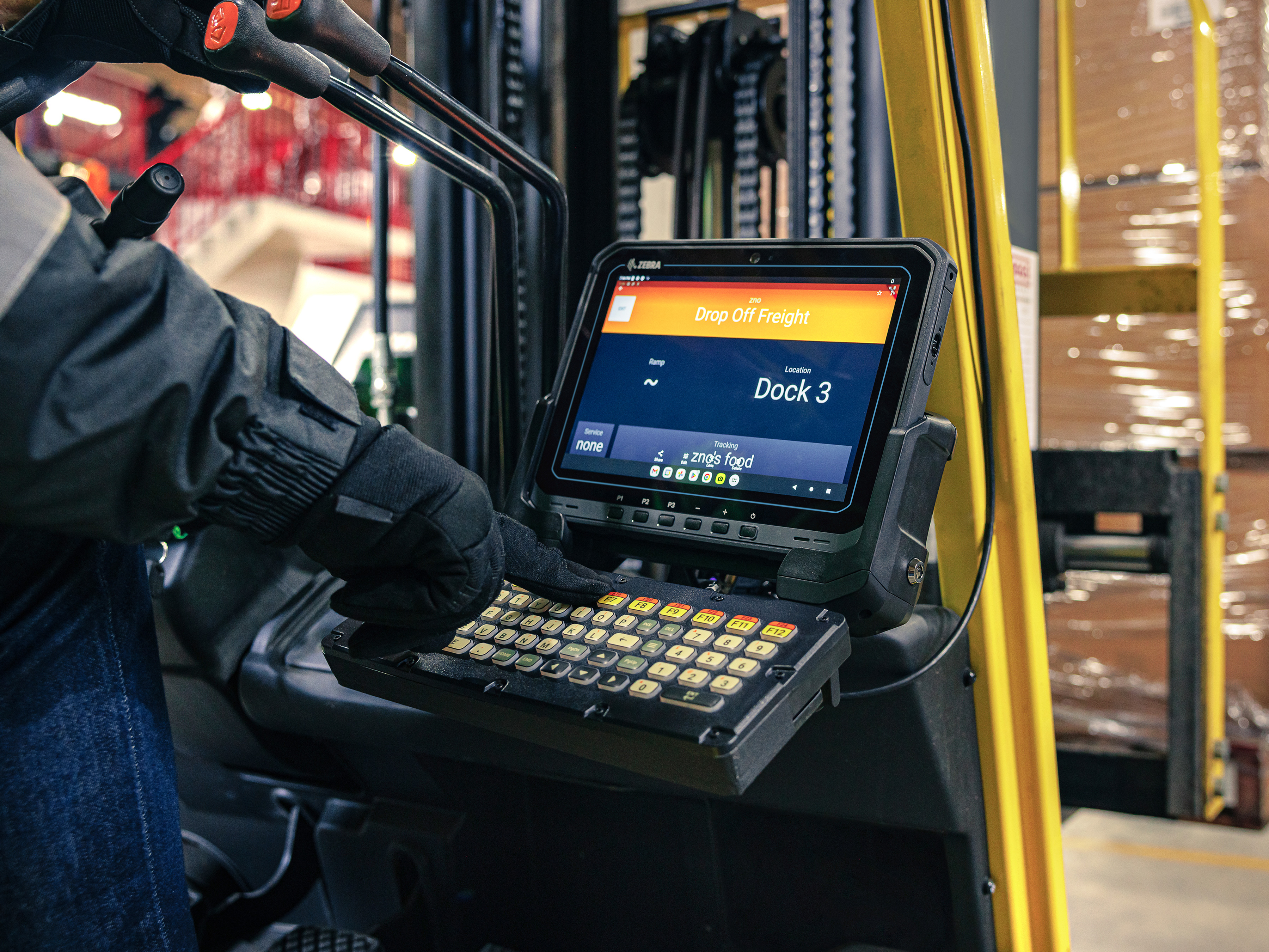 Forklift operator using a Zebra mounted tablet in a warehouse.