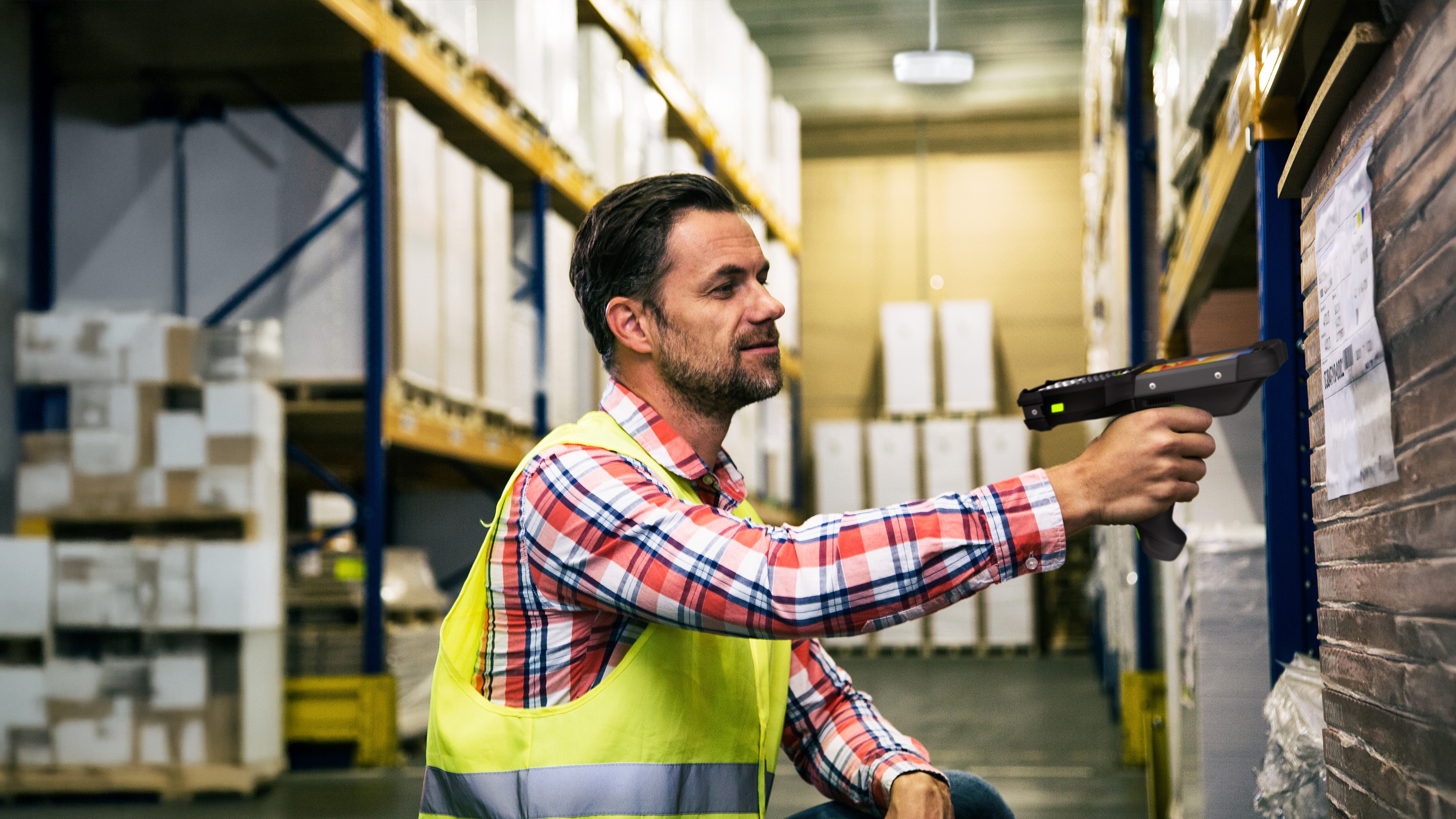 Warehouse worker scanning pallet label using a Zebra mobile computer