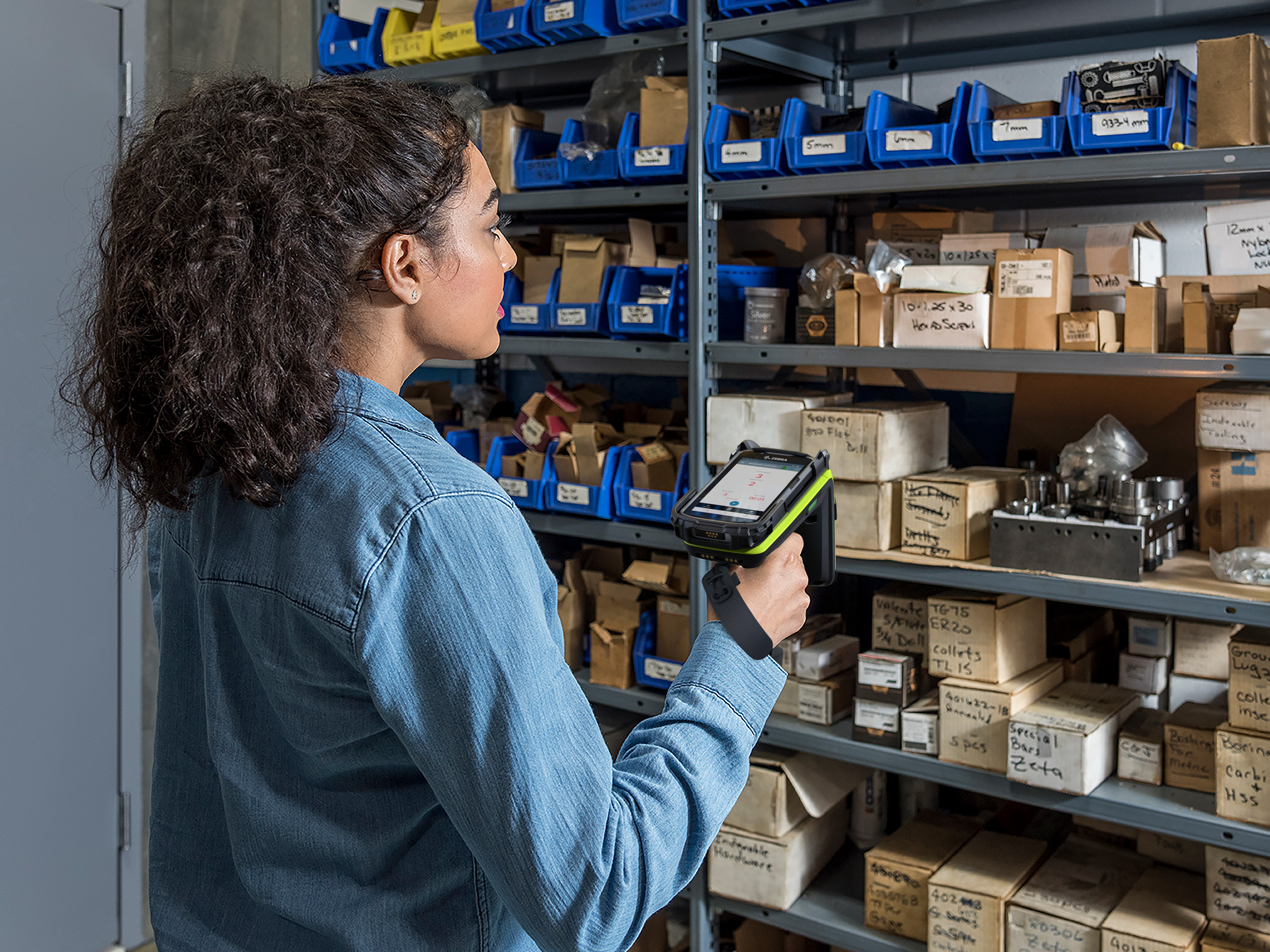 Warehouse worker scanning items on shelves using a Zebra Rugged Scanner
