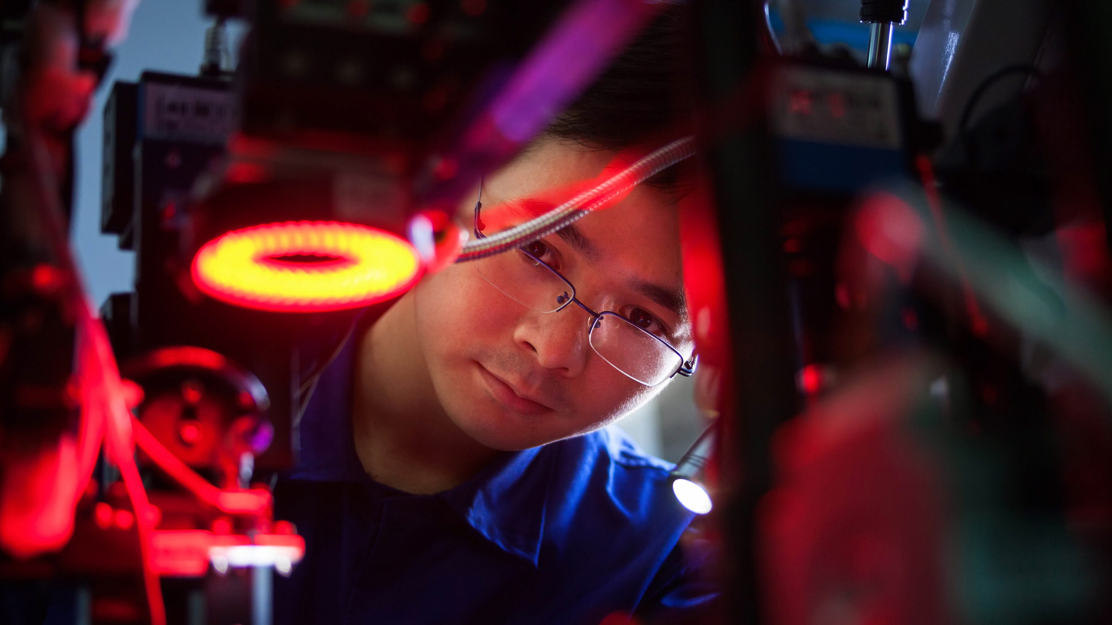 A close up of an engineer who is inspecting machinery.