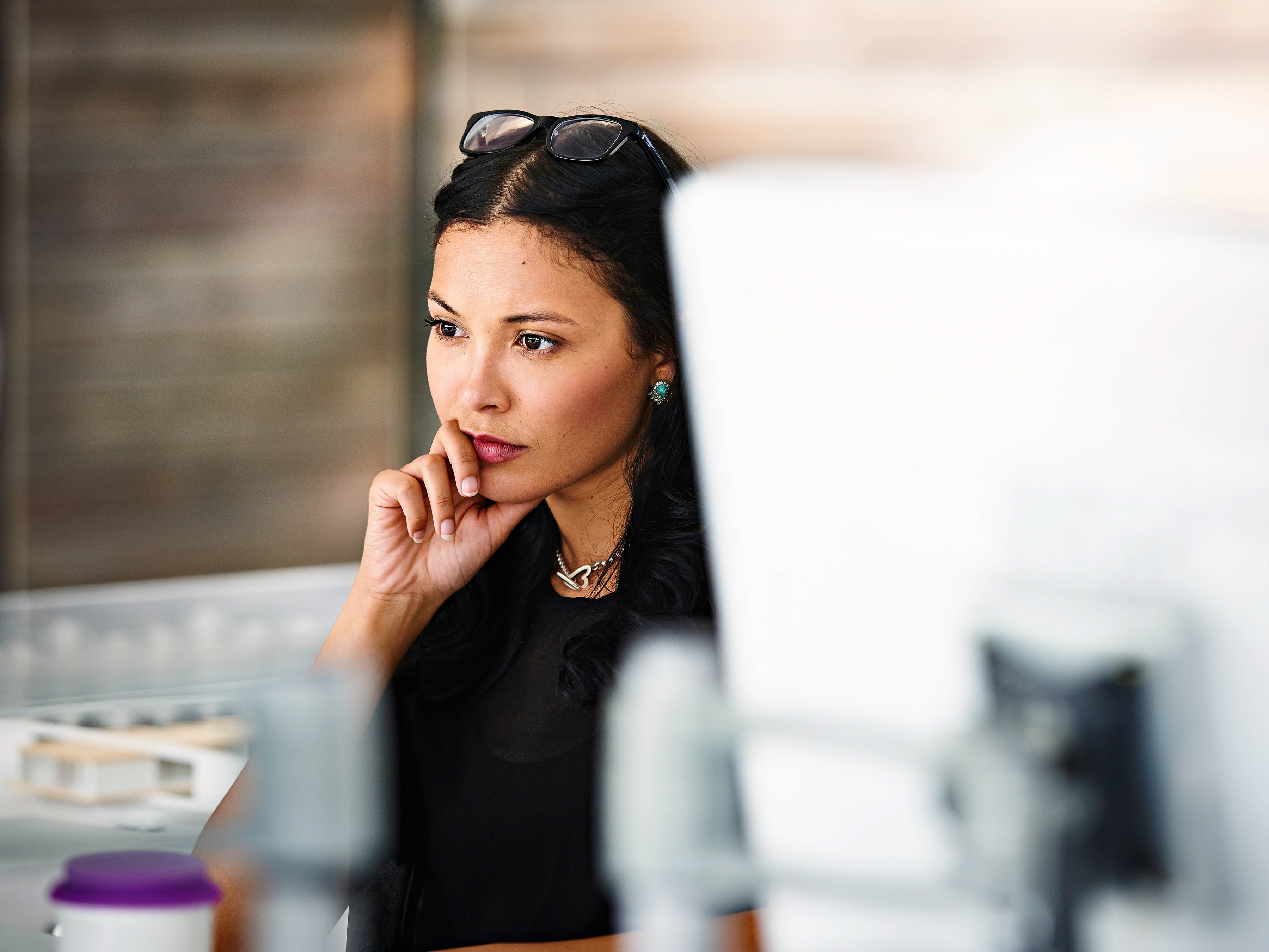 An employee is focusing while sitting at a desk in an office.