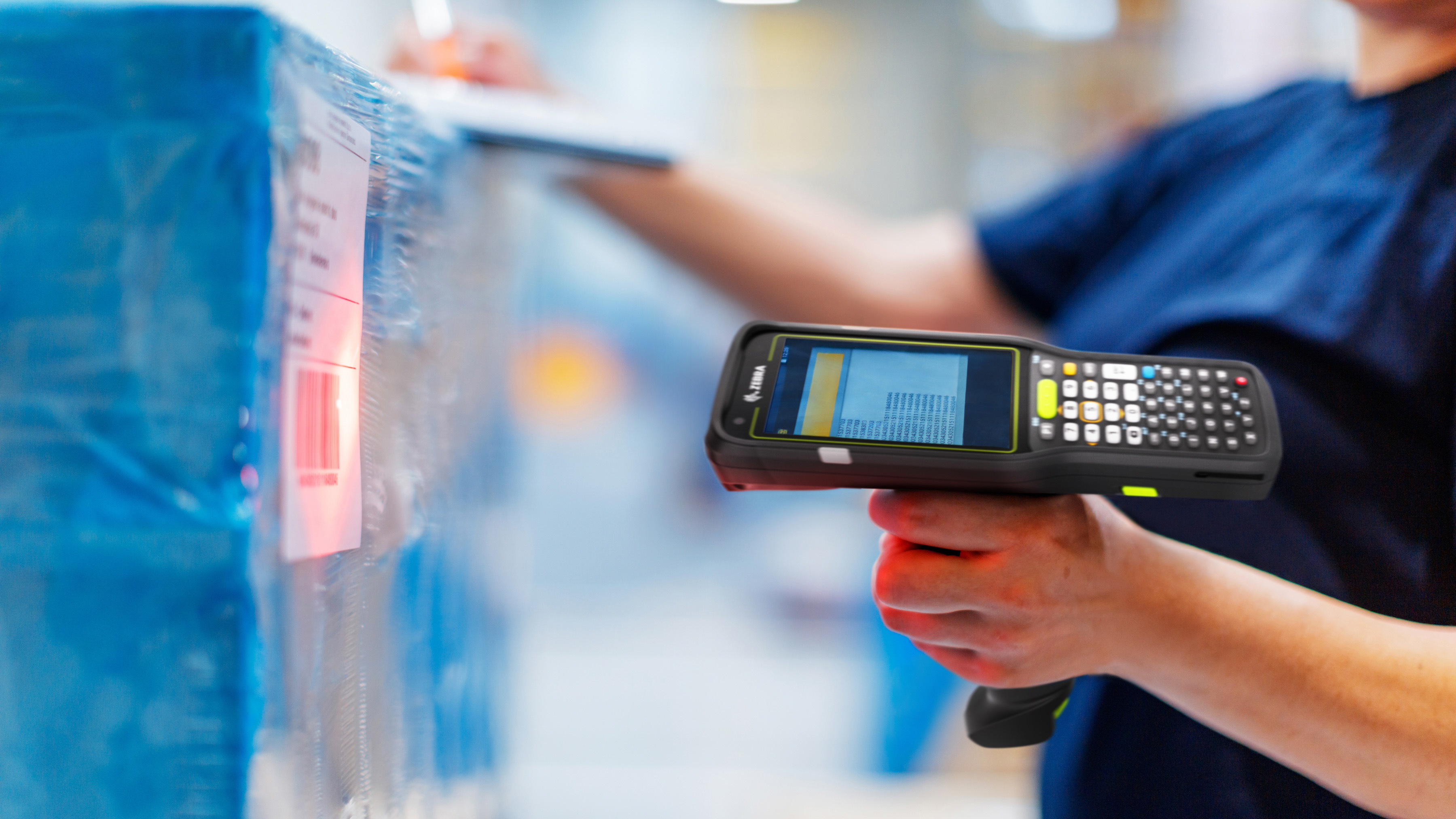 Worker using a Zebra handheld mobile computer to scan a pallet barcode.