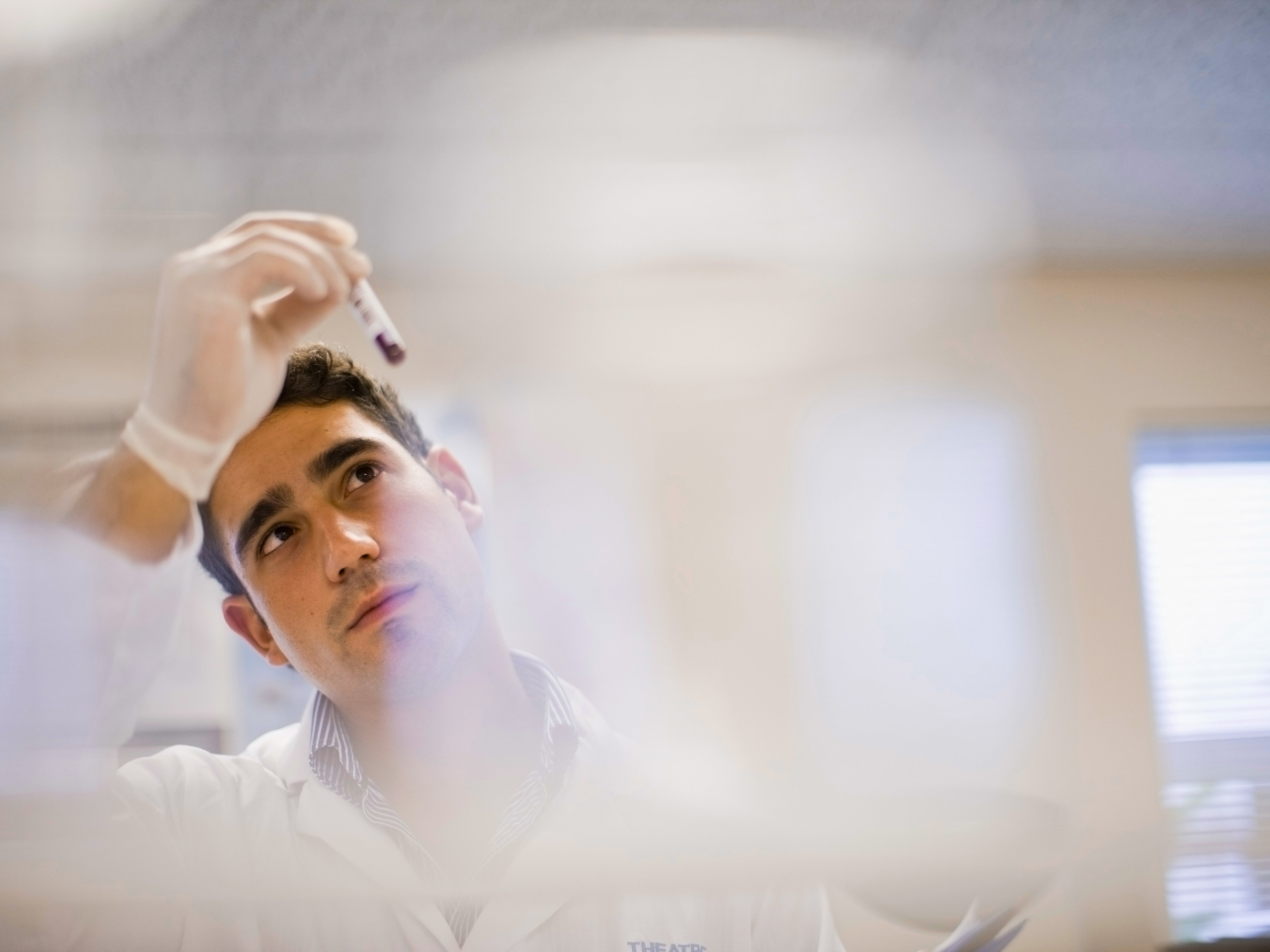 Medical professional analyzing a sample in a laboratory.