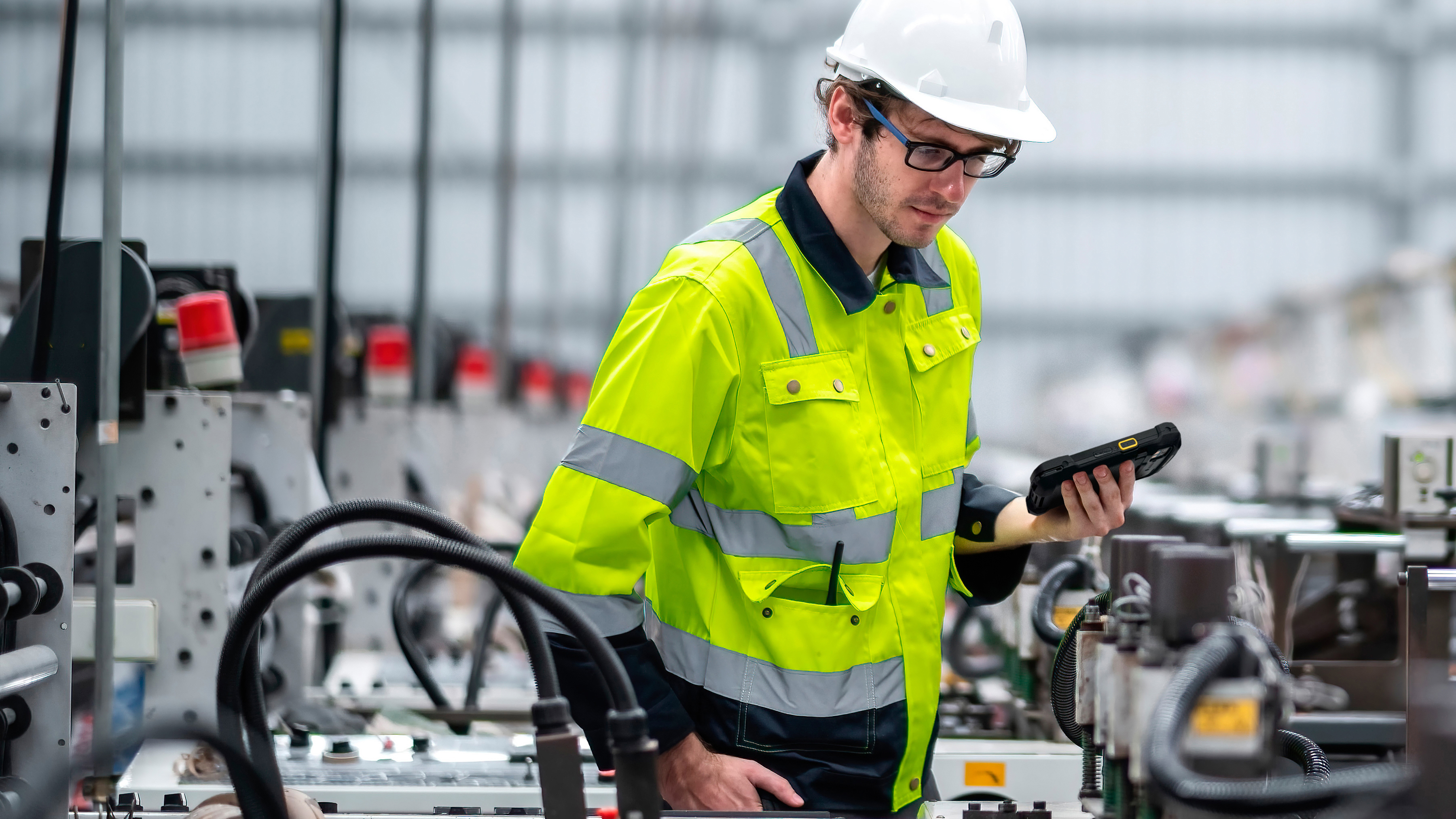 Engineer holding a tablet inspecting a production line. 