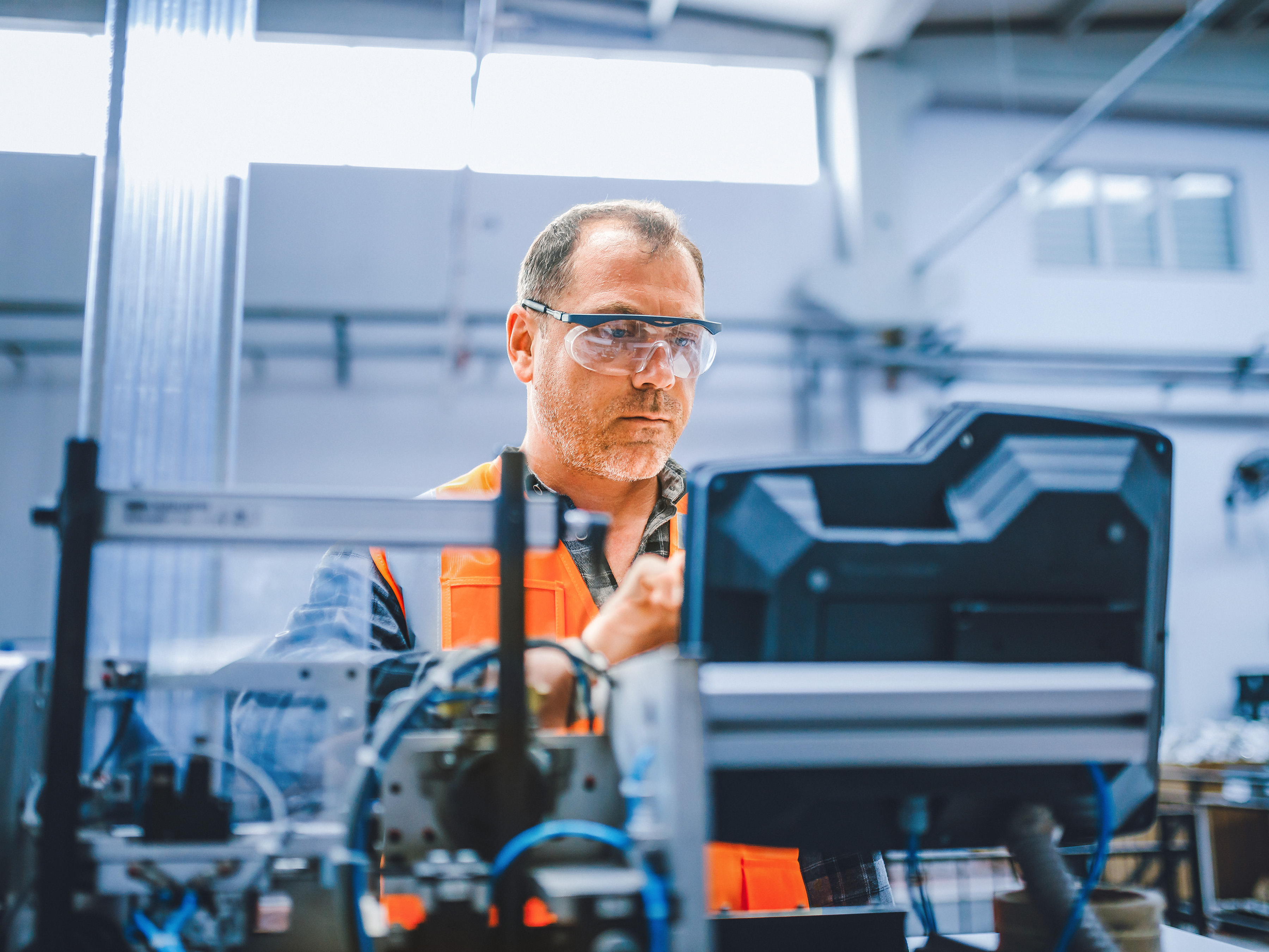 An industrial worker is managing equipment in a factory.