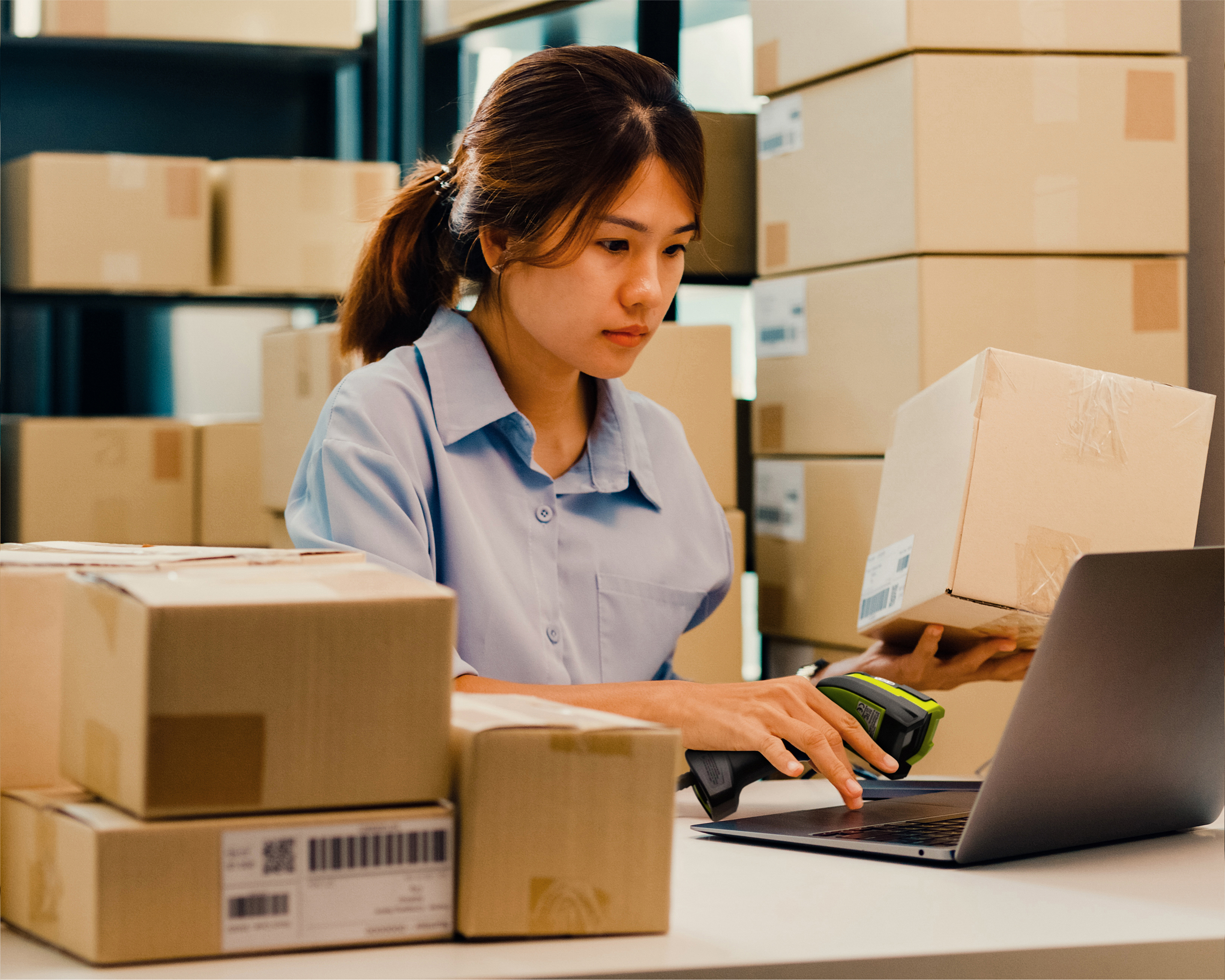 An employee handling box deliveries using a Zebra handheld barcode scanner.