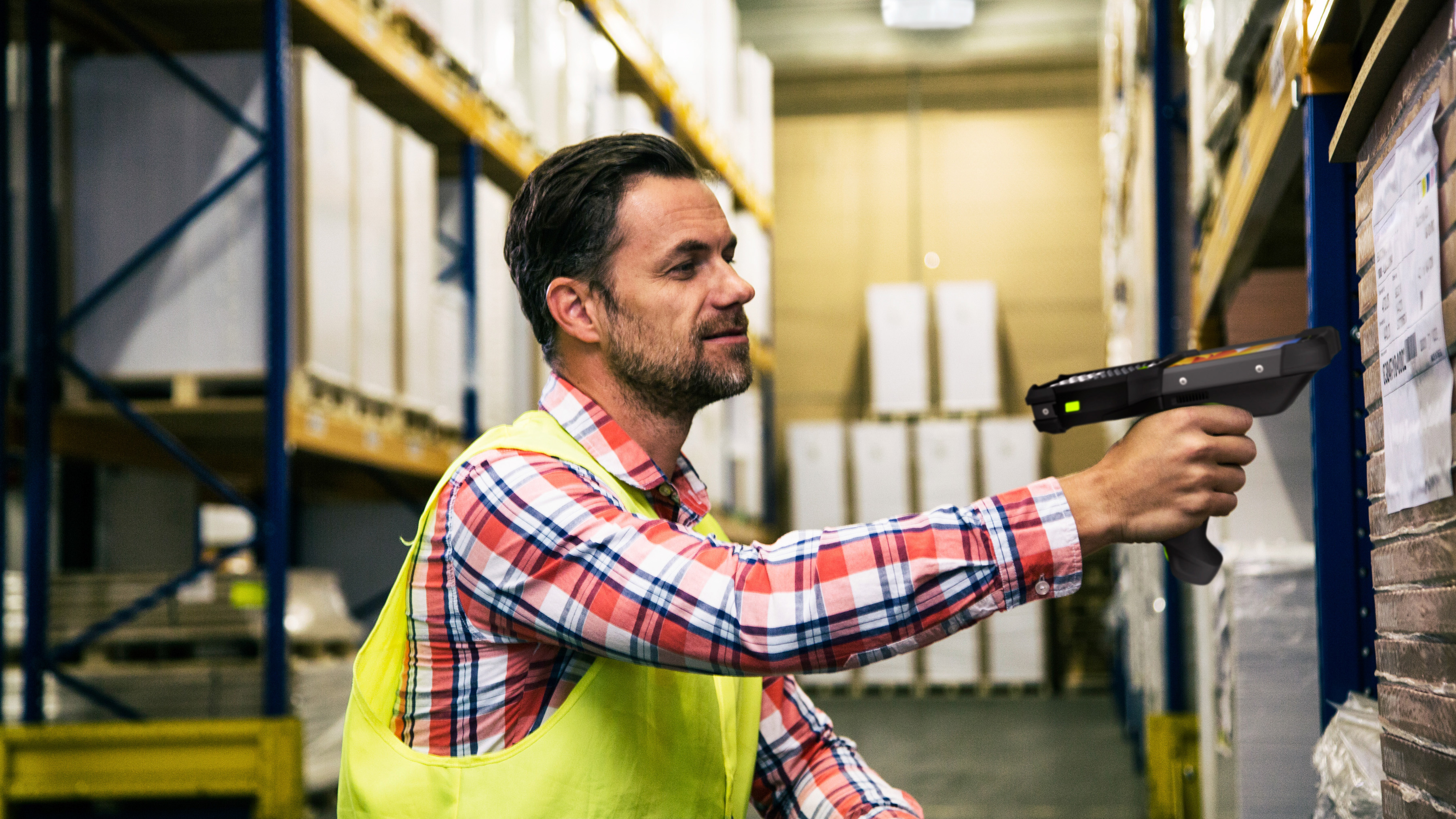 Retail employee using a Zebra handheld mobile computer to scan a pallet.