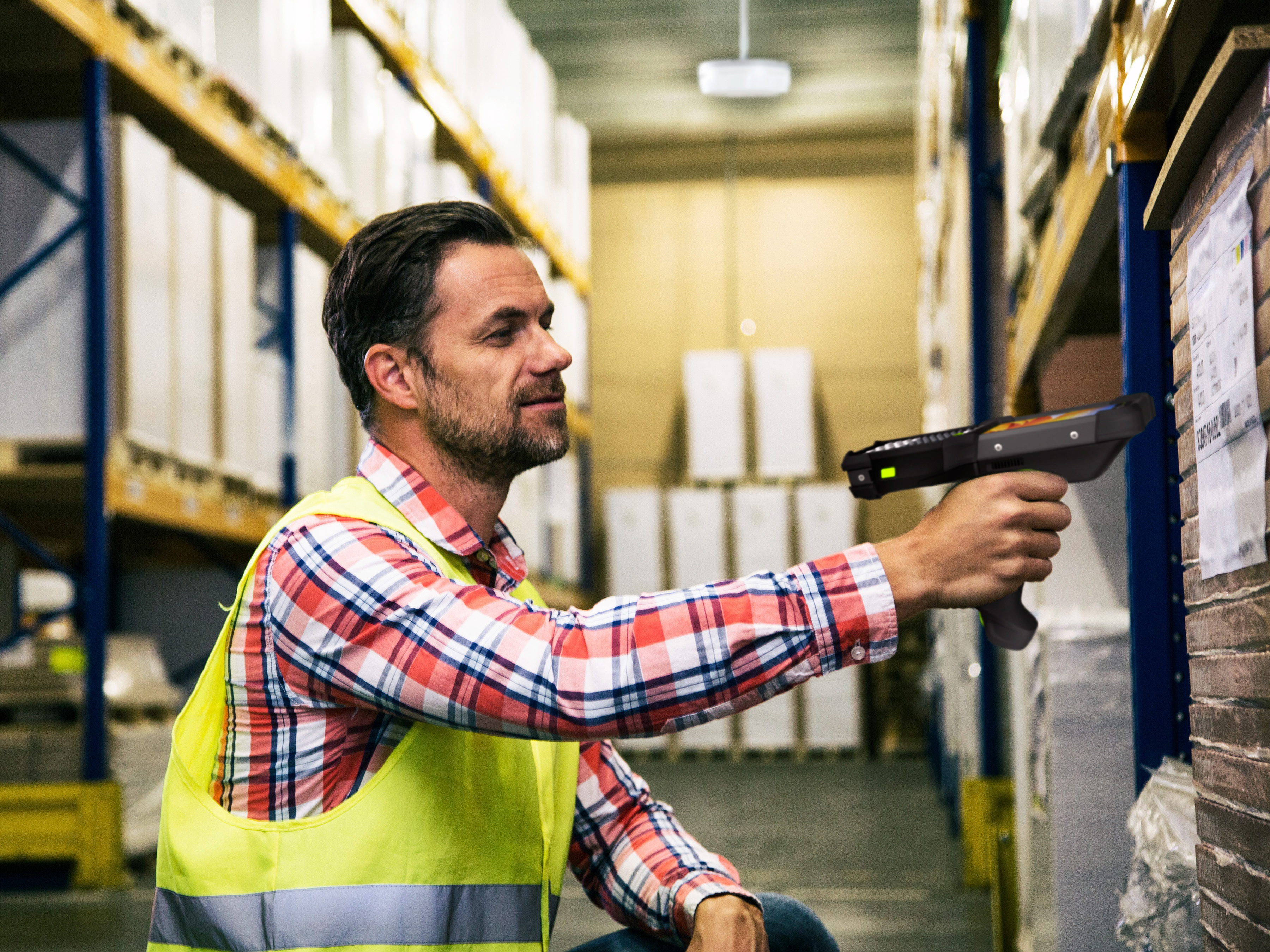 Retail employee using a Zebra handheld mobile computer to scan a pallet.