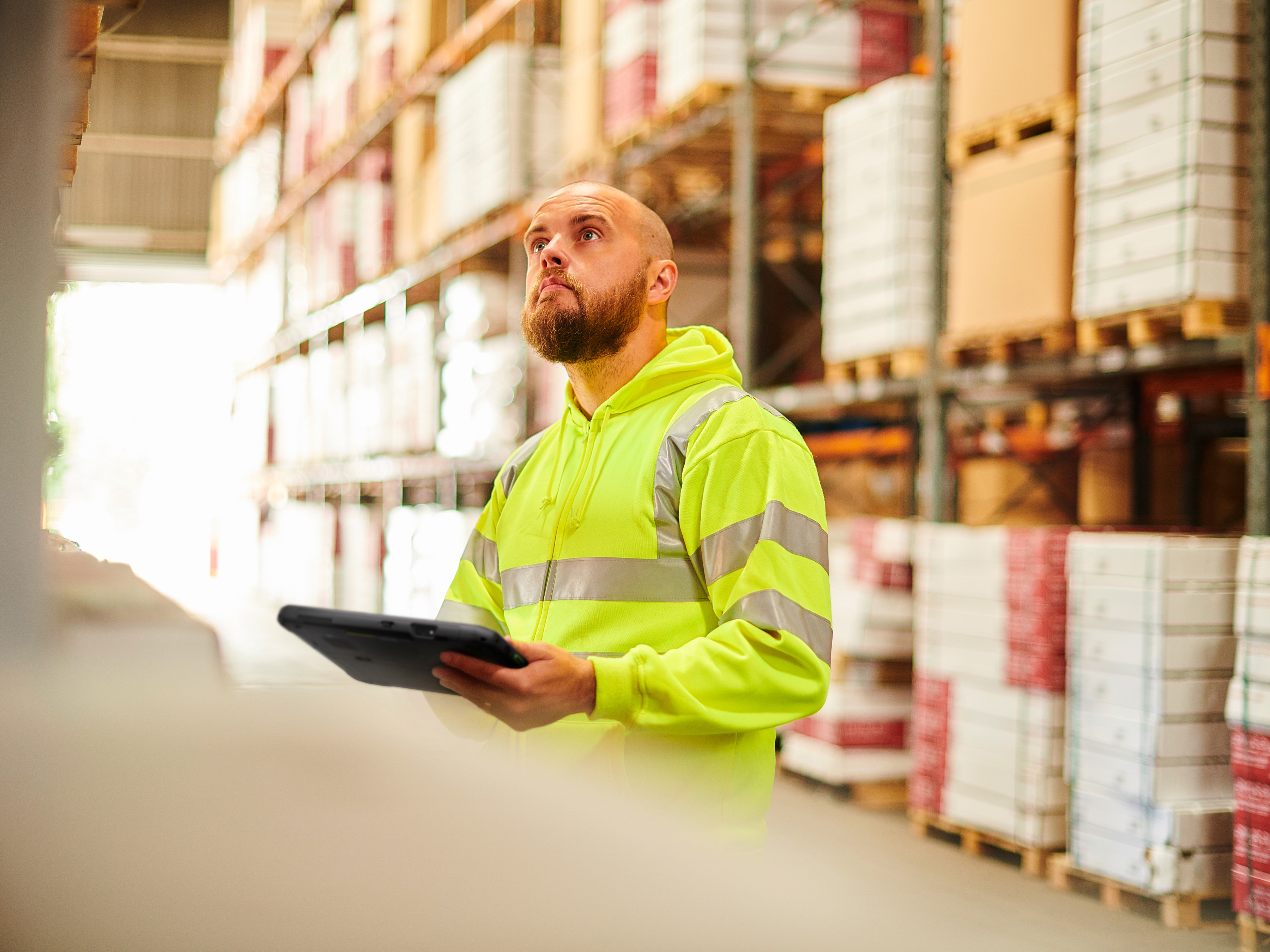 Warehouse worker with a Zebra tablet in a store room.