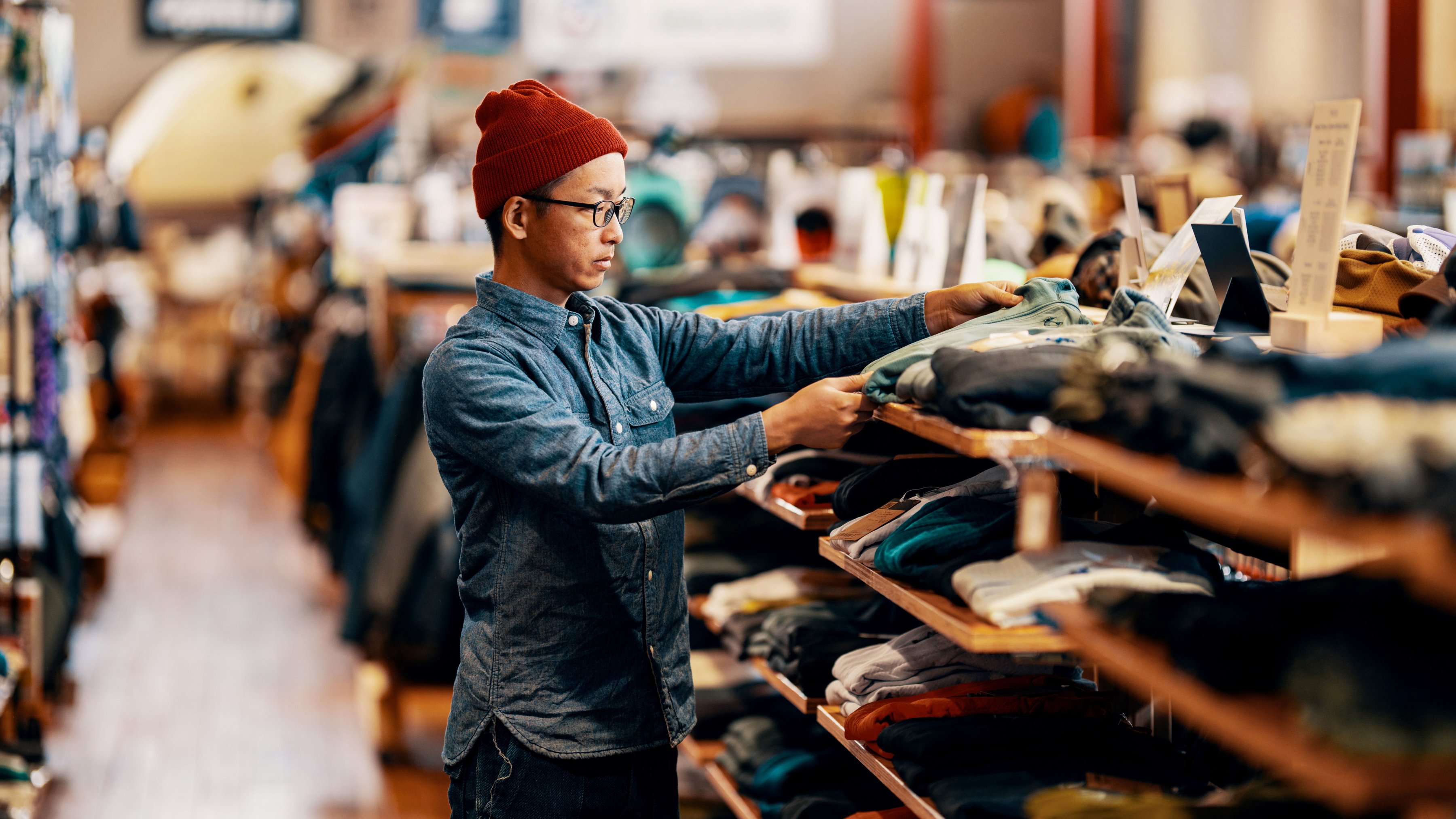 Employee folding clothing in a retail store. 