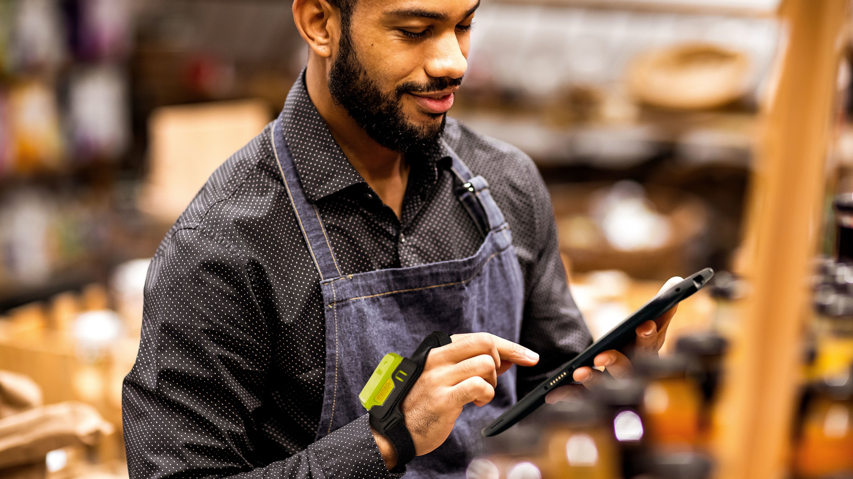 A retail employee using a tablet to review stock in a store's front-of-house.