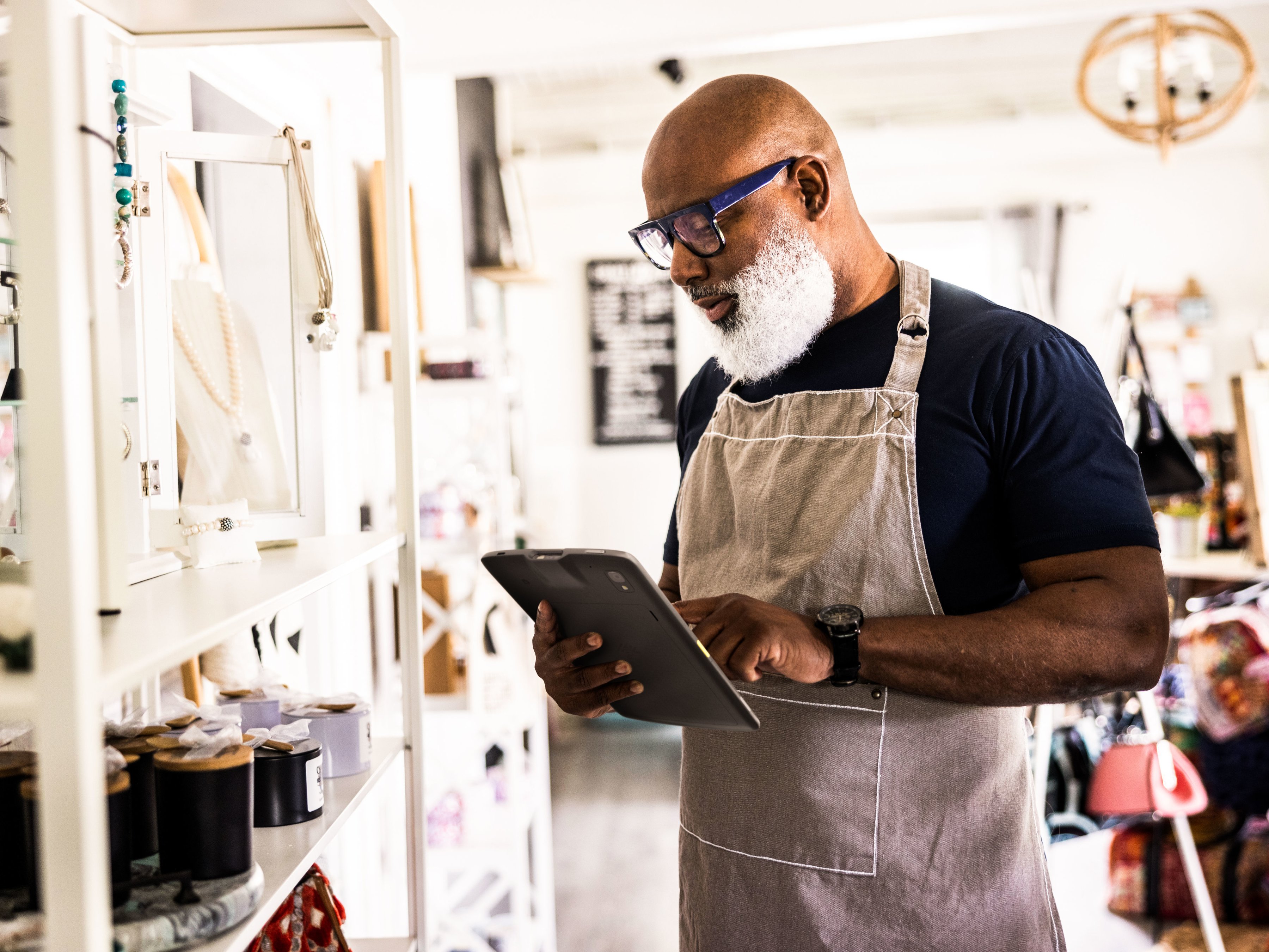 A front-of-house employee using a tablet to check inventory inside of a retail store.