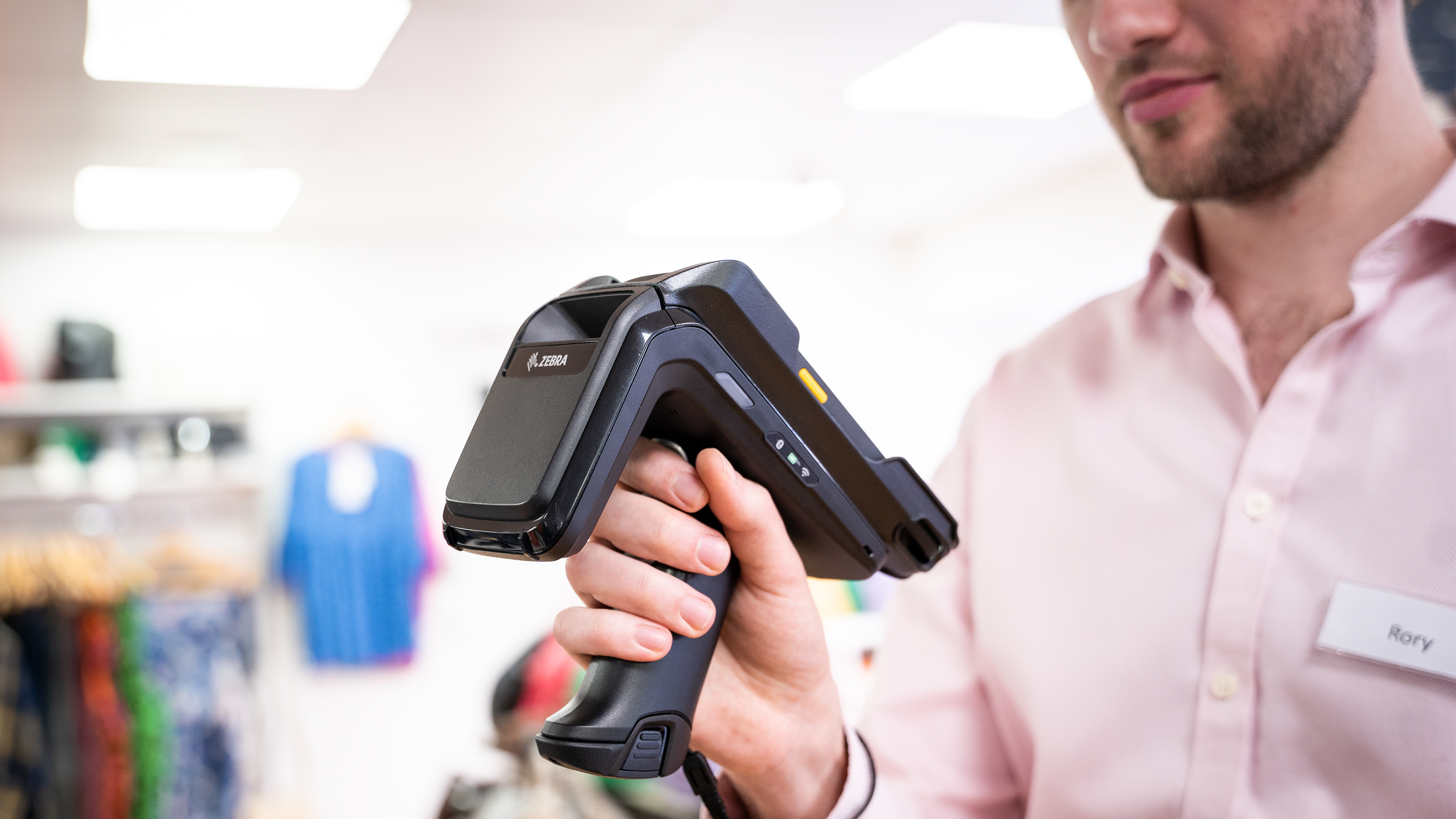 Retail worker using RFD40 connected to TC22 to read RFID tags in a store.