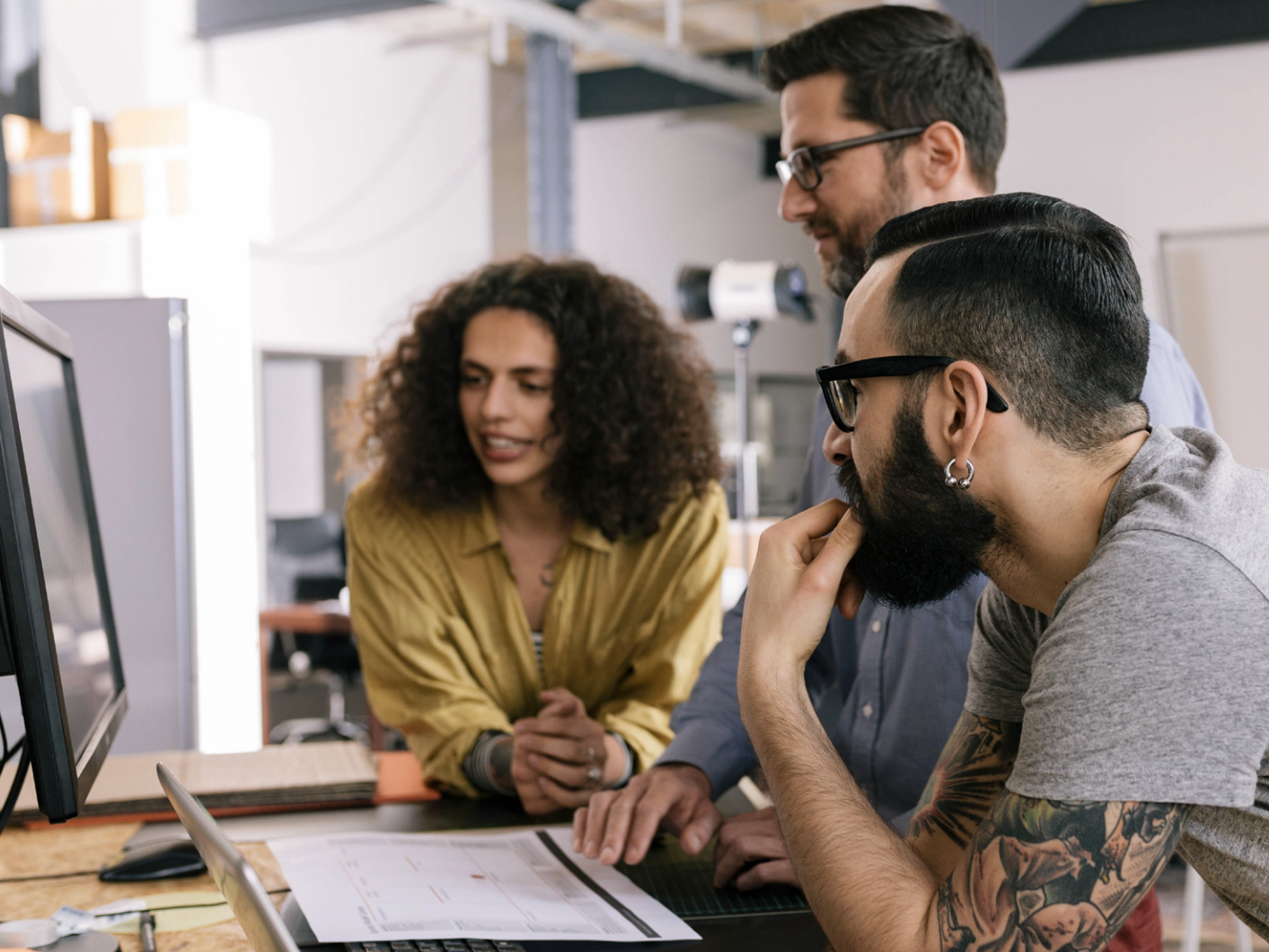 Workers in office looking at computer