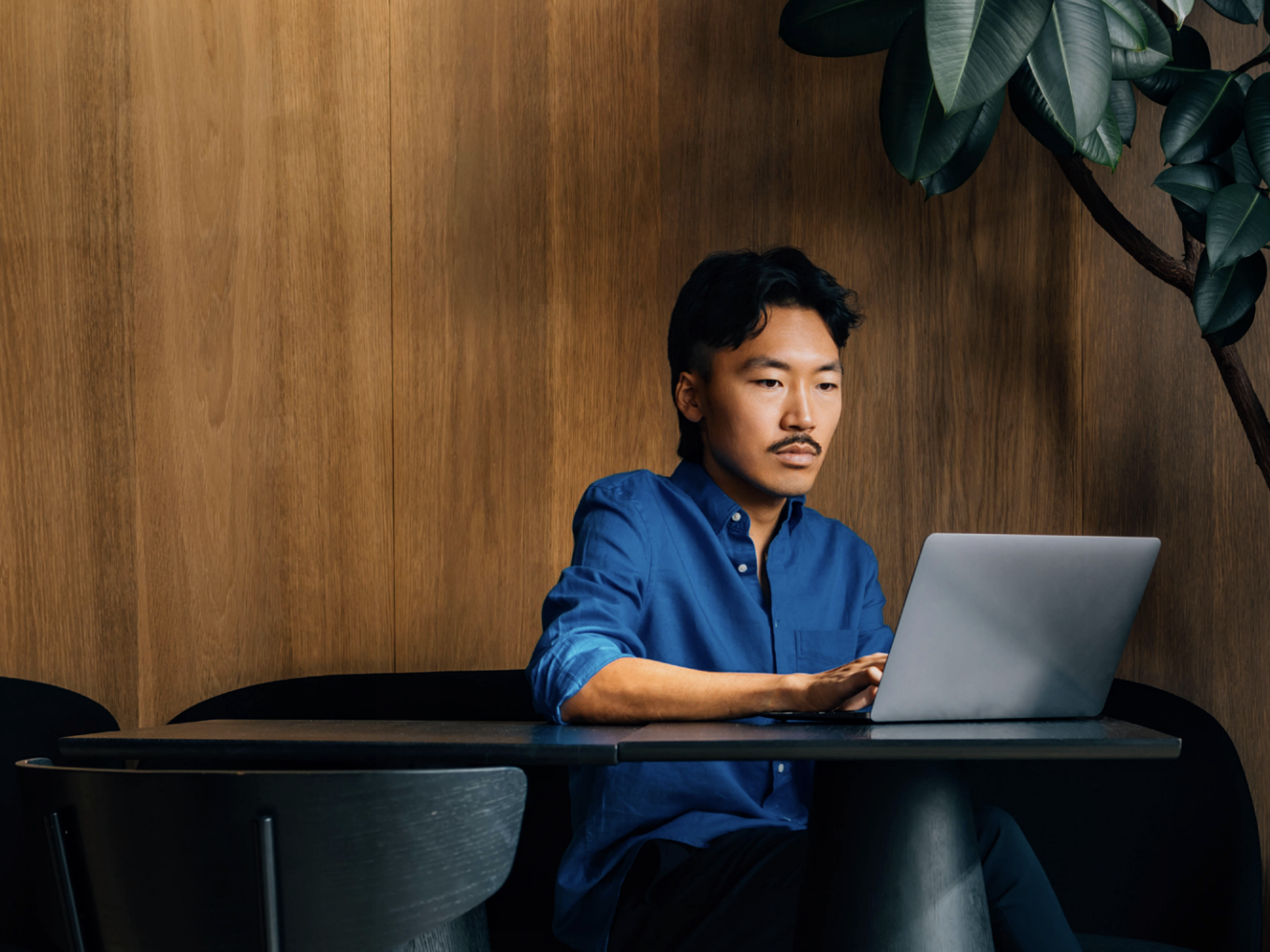Employee at table working on laptop