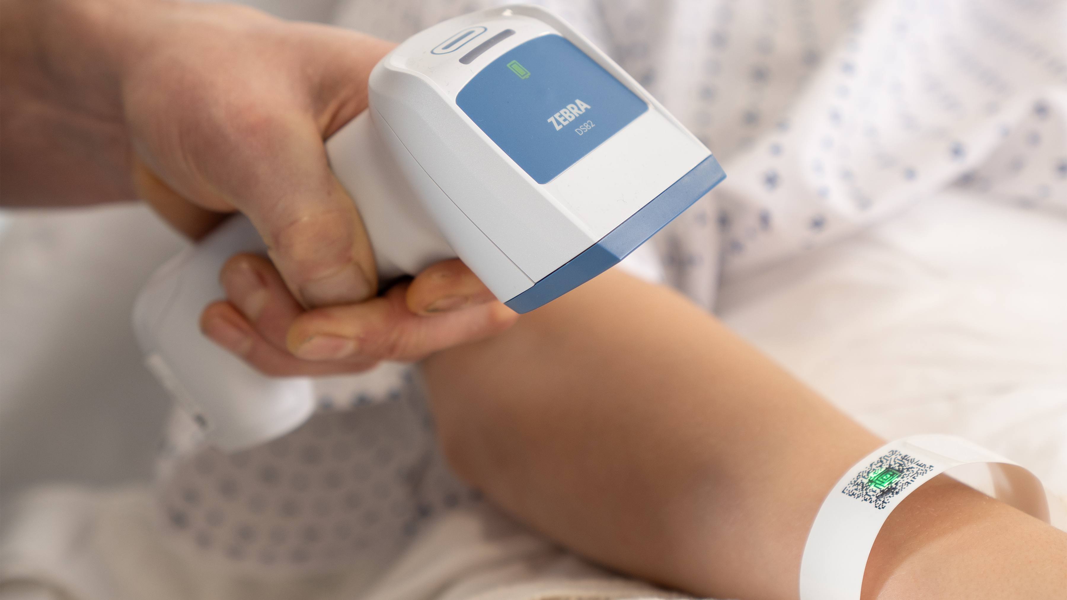 A doctor using a DS82hc healthcare scanner on a patient wristband.