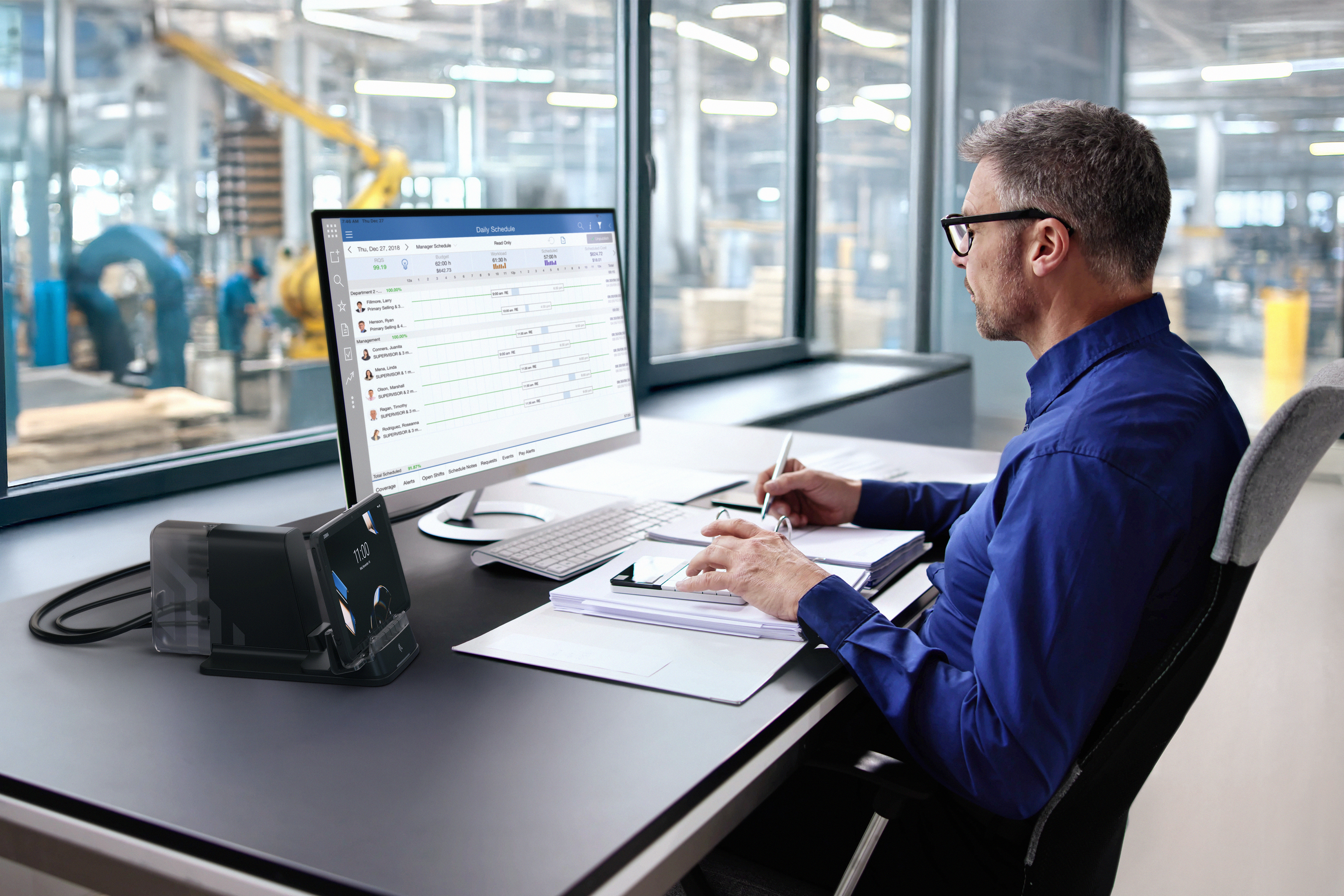 Man using Workstation Connect software on a display screento view office staff schedule.