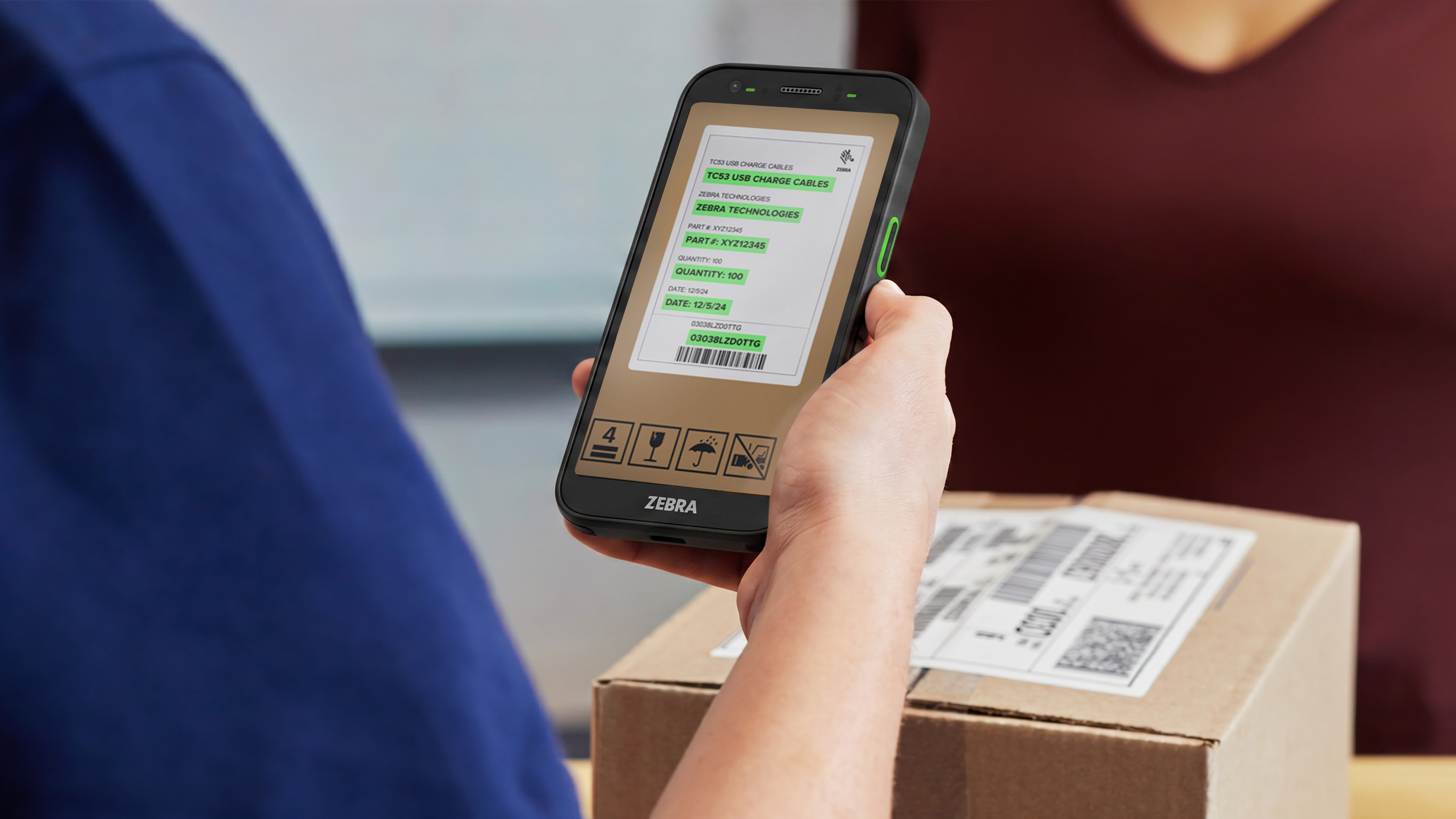 Photo of a postal worker using a TC501 to scan a UPC on a box. 