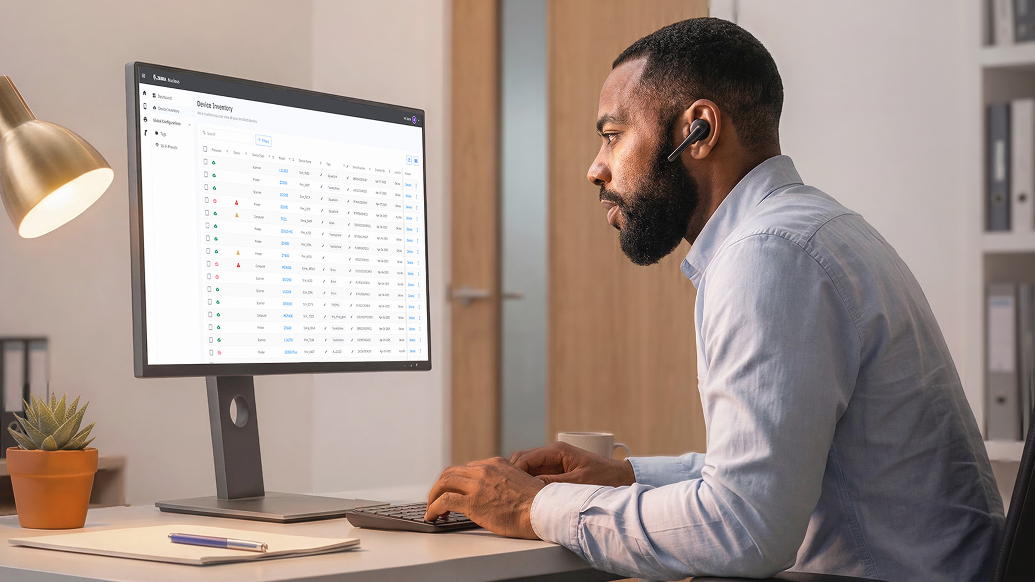 Man working at a desk reviewing a screen with a chart of data.