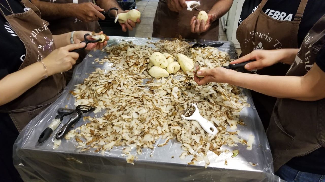 The Zebra team peeling potatoes at St. Francis Table as part of the #50HourChallenge