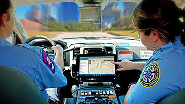 Two EMS technicians look at a Zebra XSLATE R12 rugged tablet mounted in their ambulance to get directions to a call.