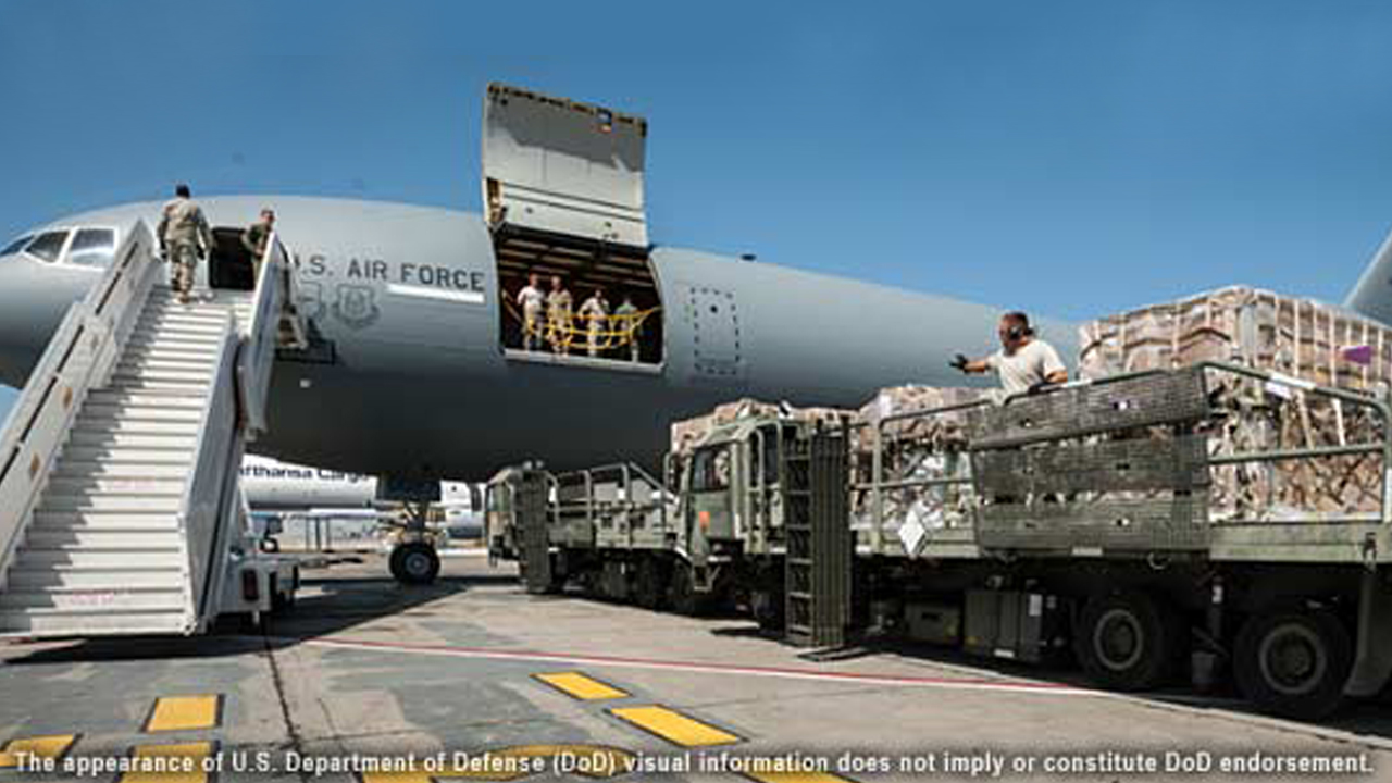 A U..S. Air Force cargo plane is loaded with equipment and pallets on a tarmac