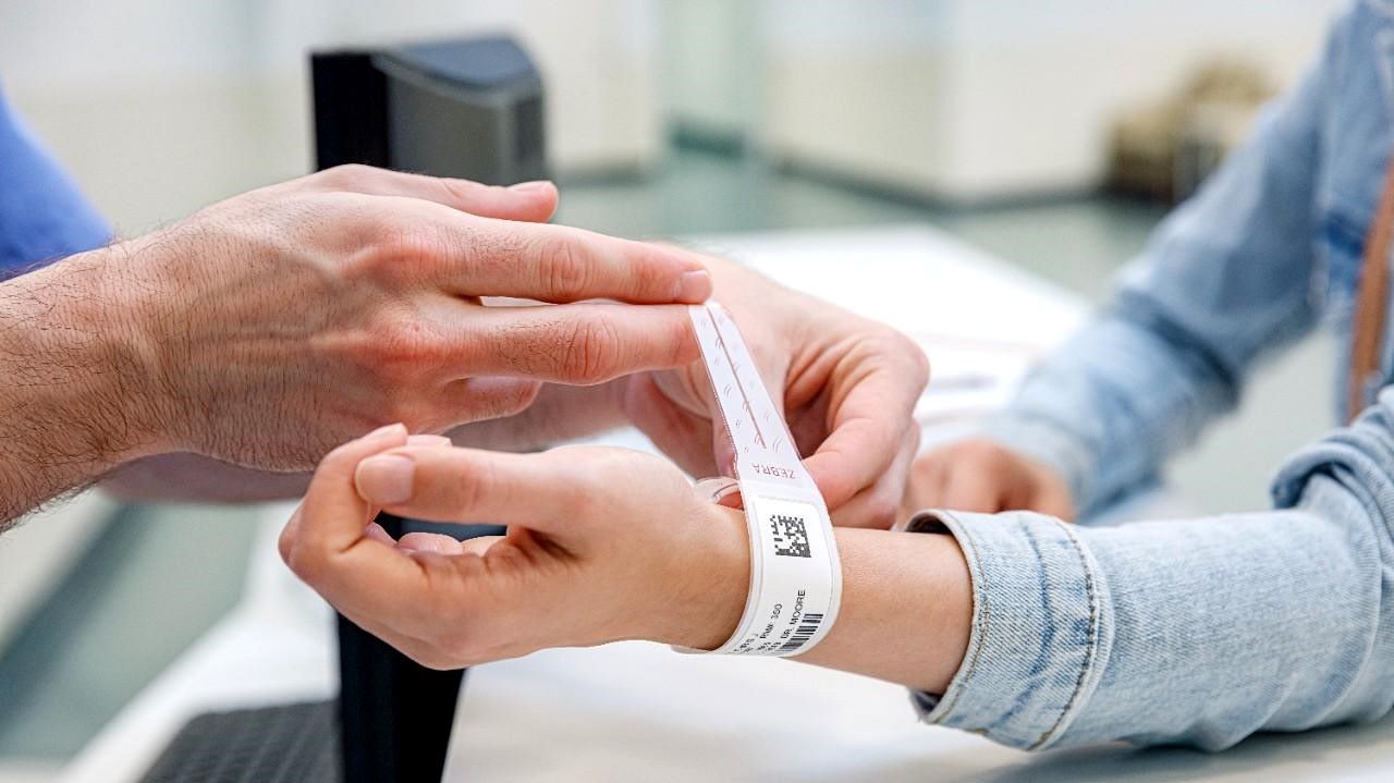 A barcoded wristband is put on a woman's arm.